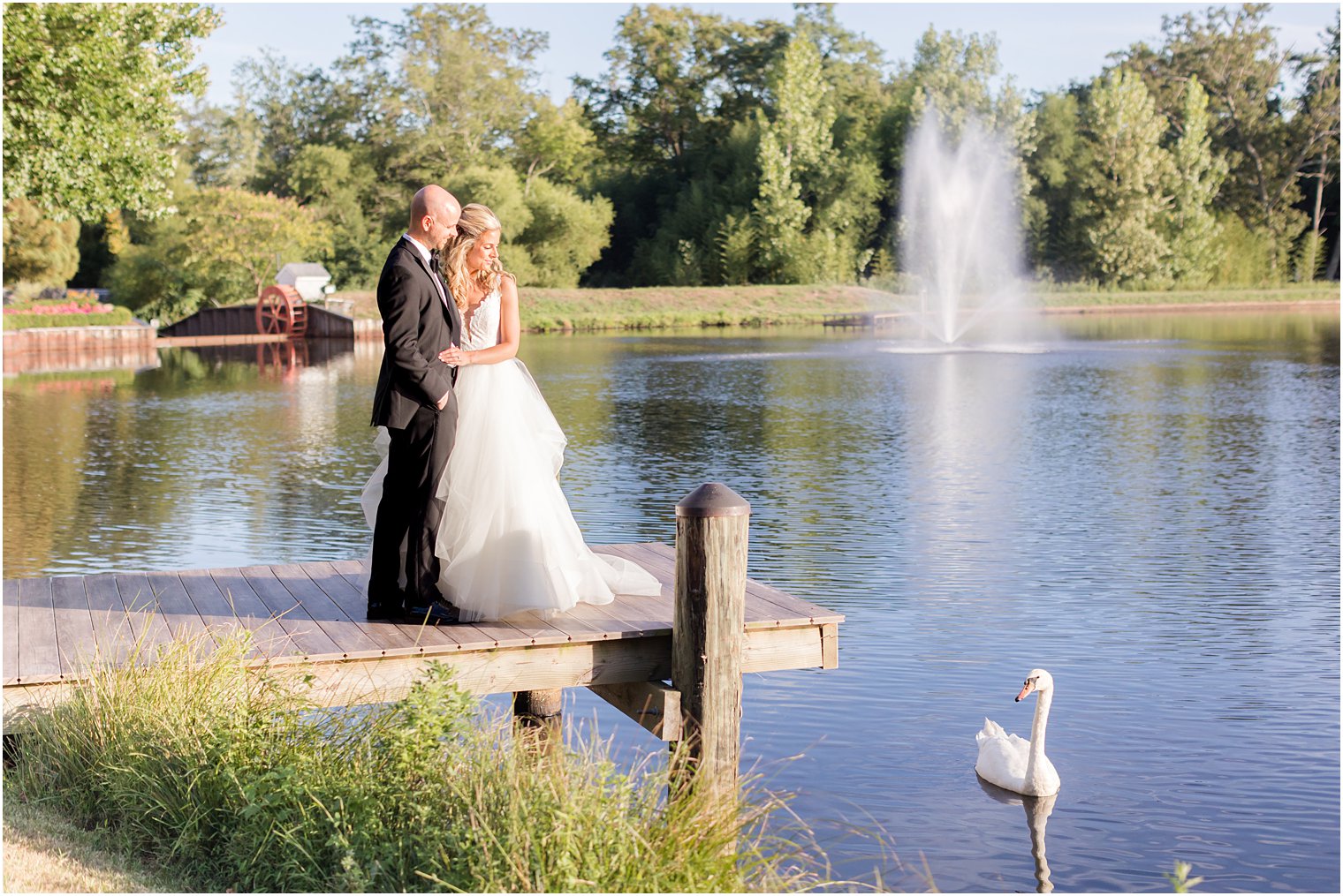 bride and groom kiss on end of dock at The Mill Lakeside Manor