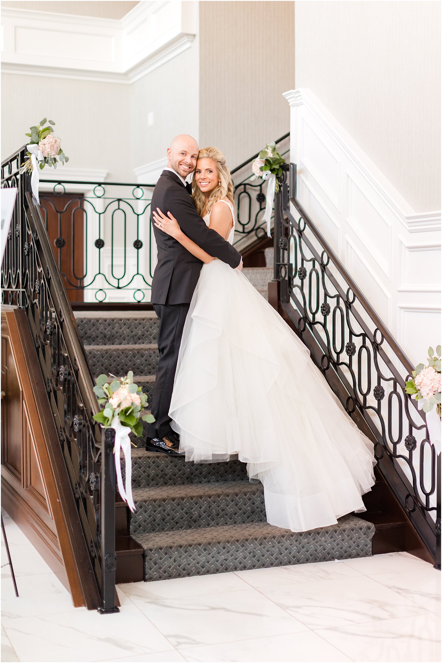 bride and groom pose on staircase inside The Mill Lakeside Manor