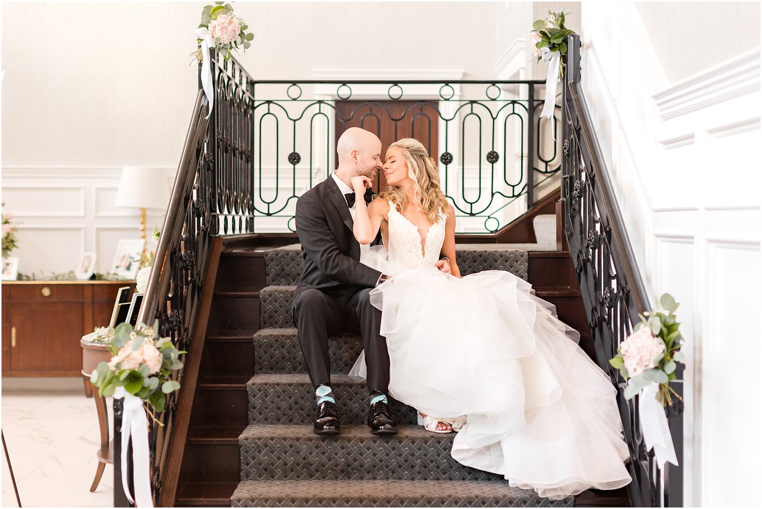 bride and groom sit on steps inside The Mill Lakeside Manor