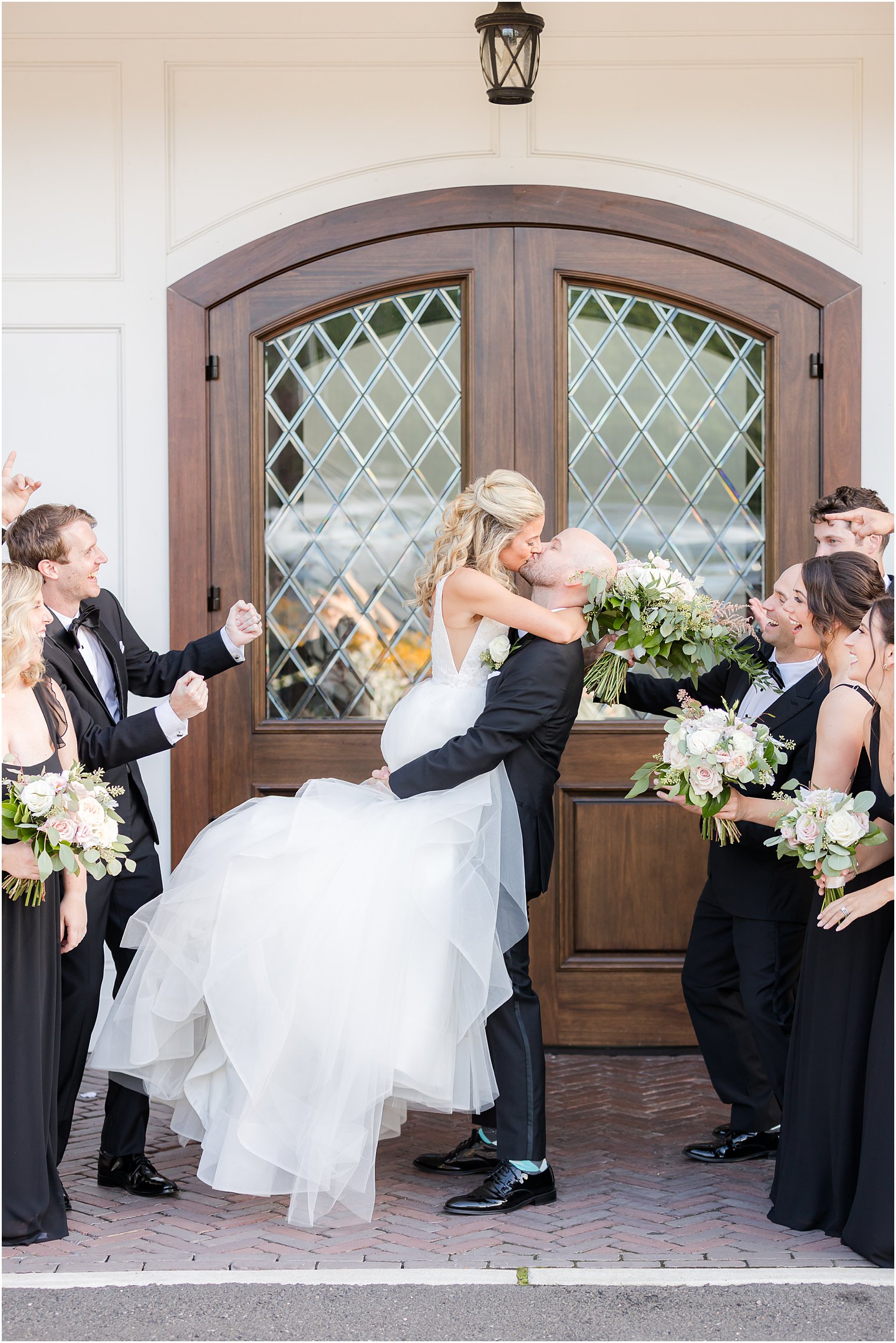 groom kisses bride lifting her up during portraits at The Mill Lakeside Manor