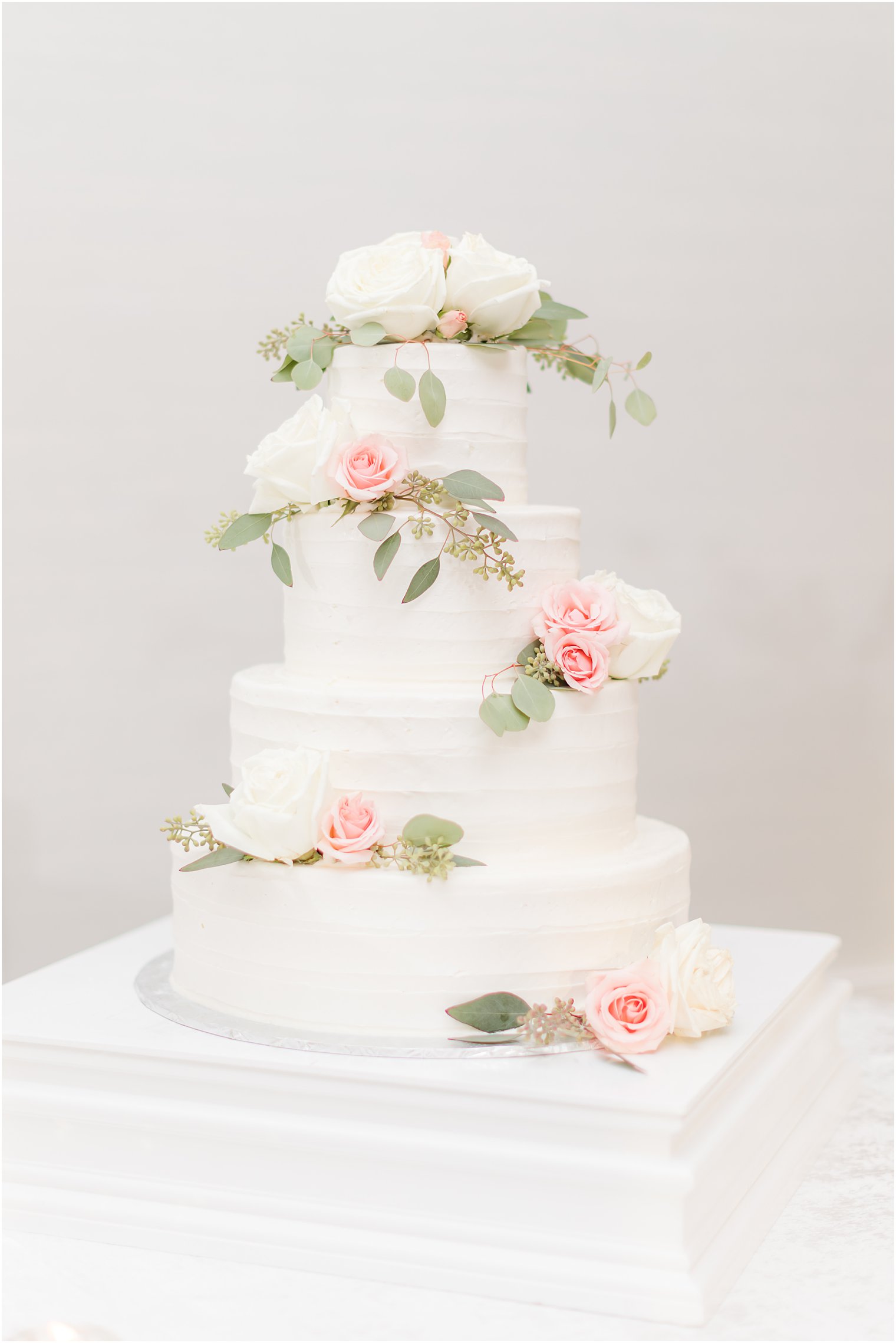 tiered wedding cake with pink and white flowers 