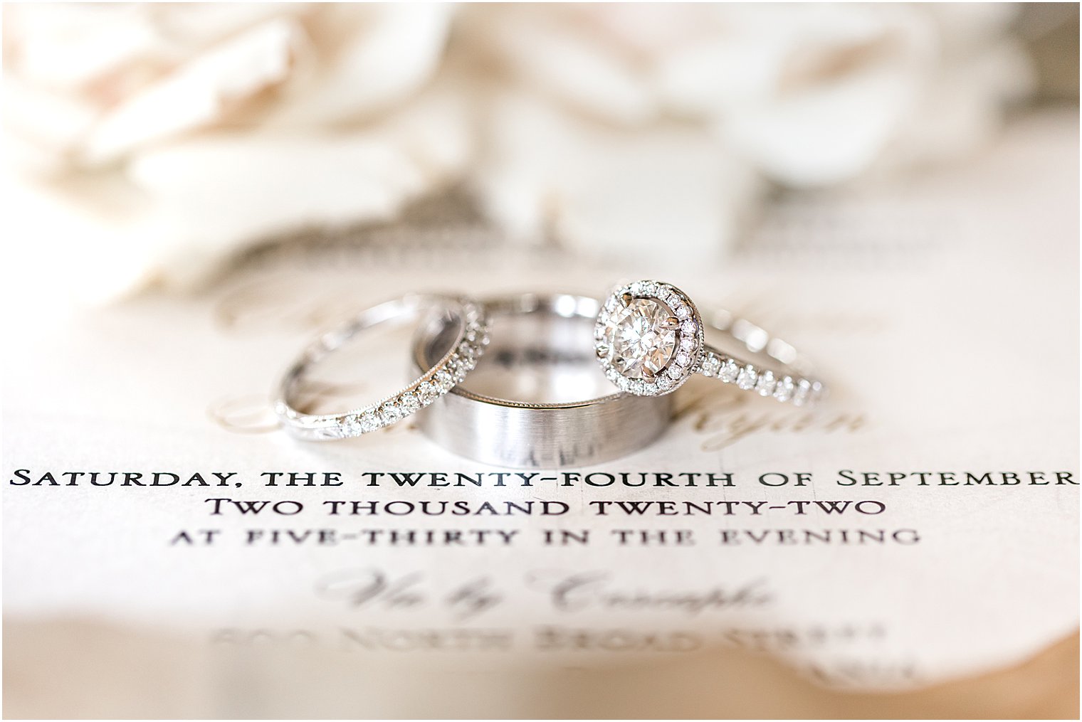 wedding rings rest on invitation before Vie by Cescaphe wedding