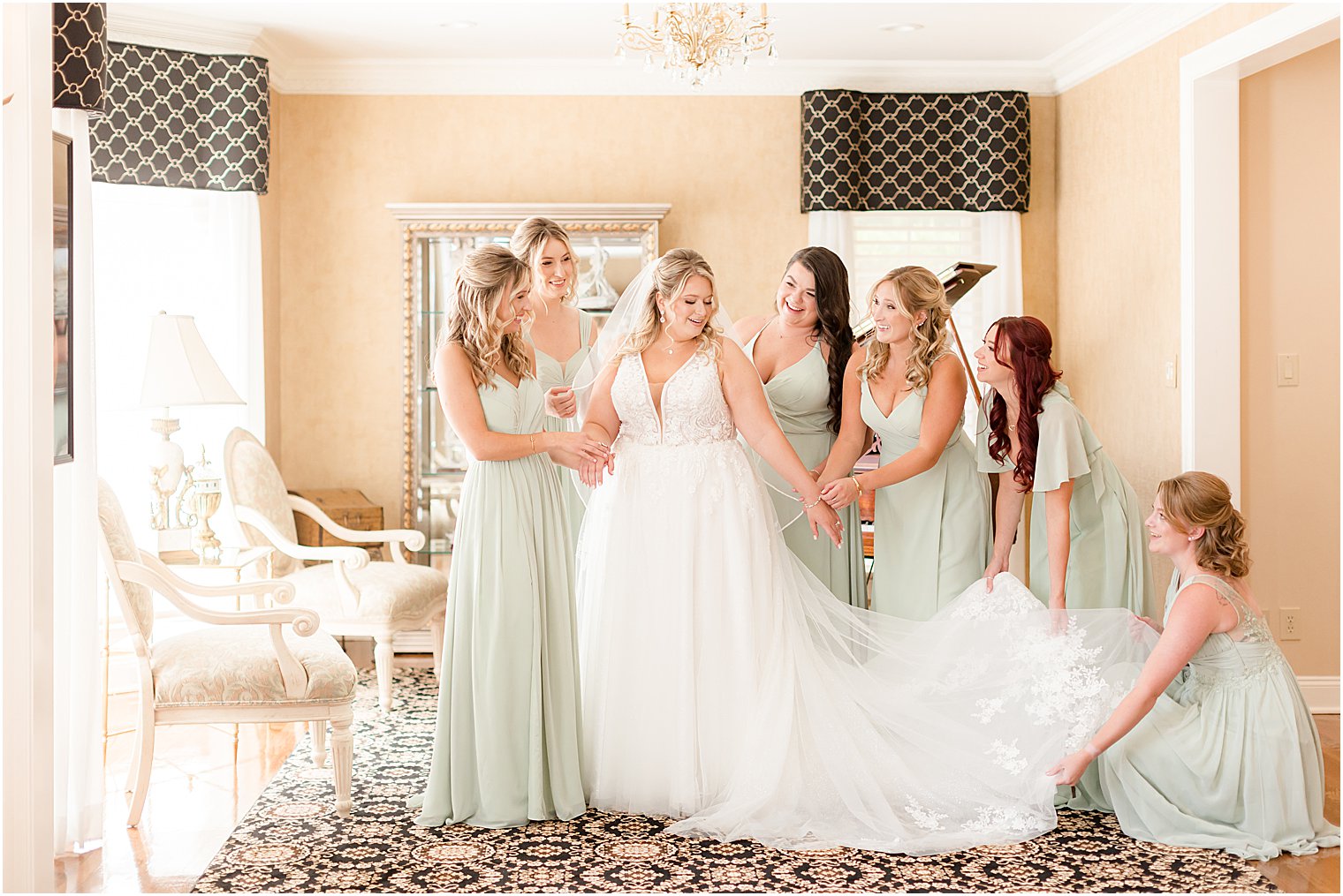 bridesmaids in mint green gowns help bride with prep before Philly PA wedding