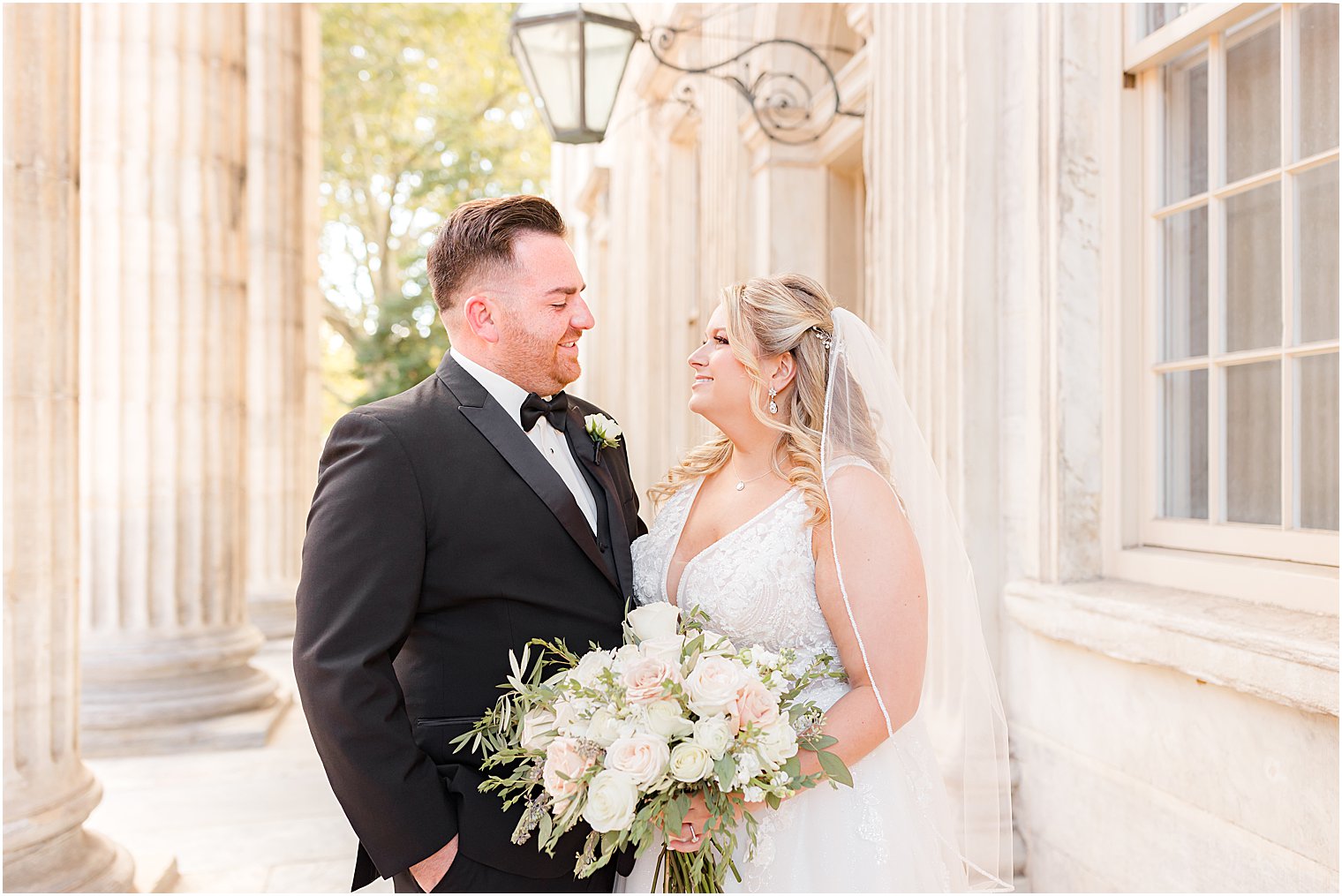 bride and groom smile together outside the First National Bank in Philly, PA