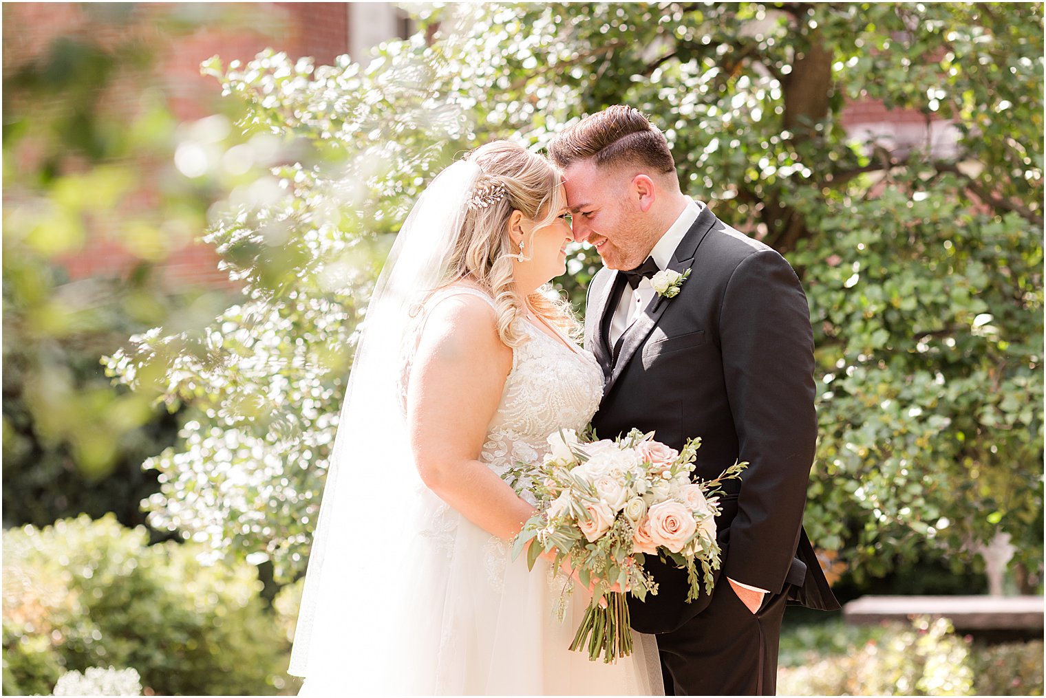bride and groom lean foreheads together inside the Benjamin Rush Gardens