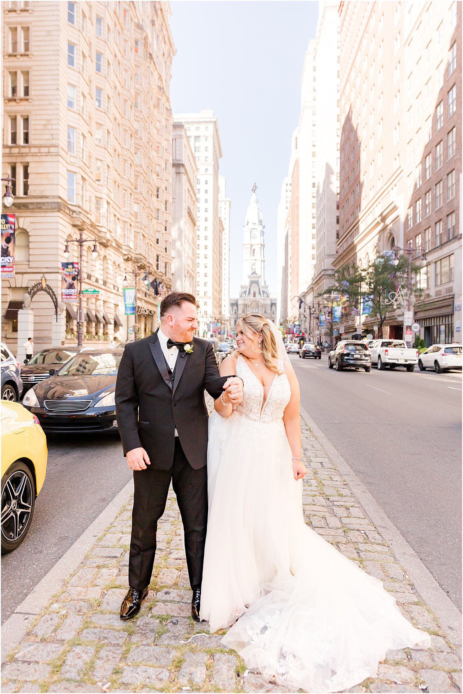 bride and groom bump hips on stone walkway in Philly PA