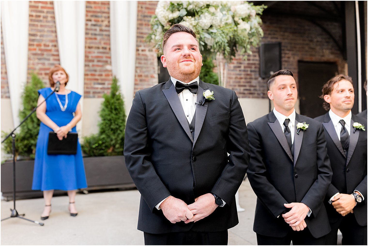 groom watches bride enter wedding ceremony 