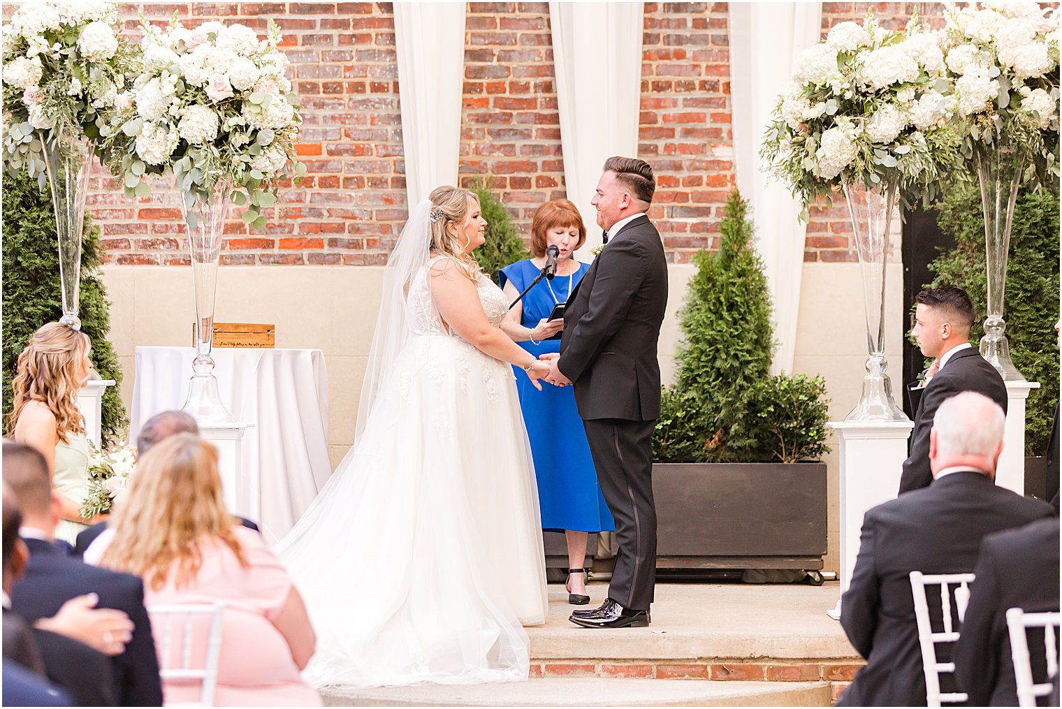 bride and groom hold hands during courtyard wedding