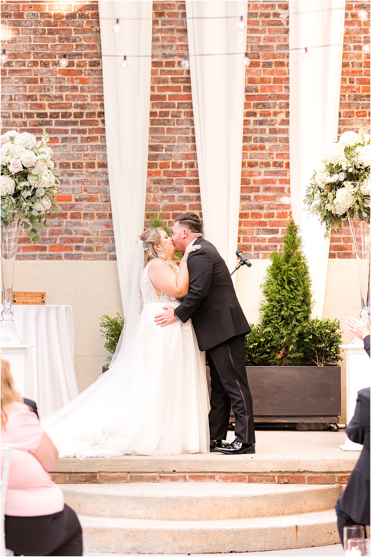 newlyweds kiss during ceremony at Vie by Cescaphe wedding