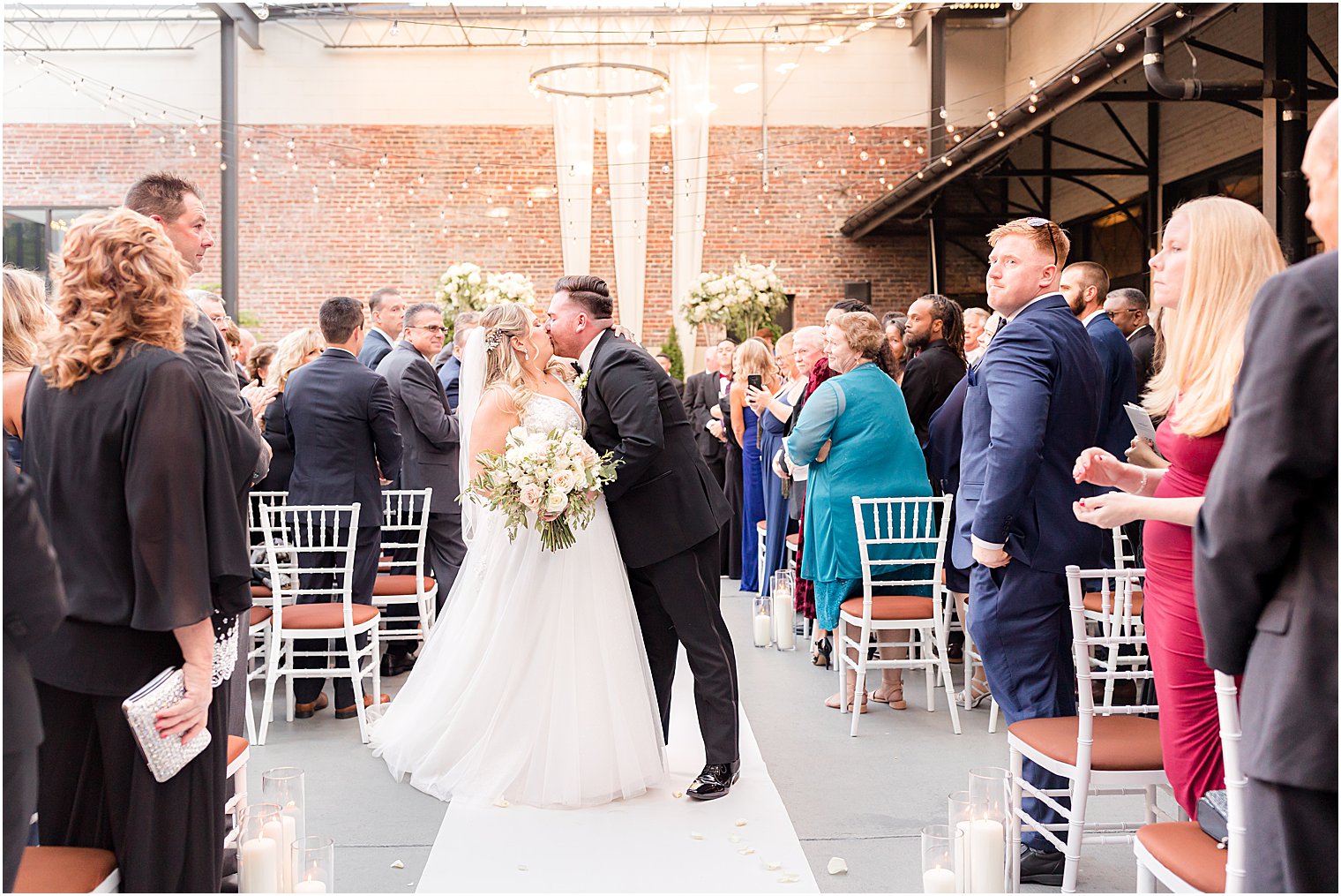 bride and groom kiss in aisle at Vie by Cescaphe
