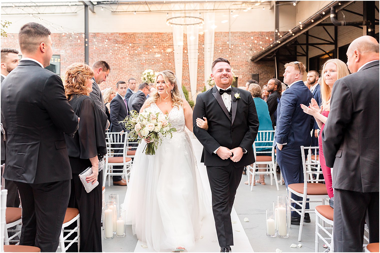 newlyweds walk up aisle after ceremony at Vie by Cescaphe