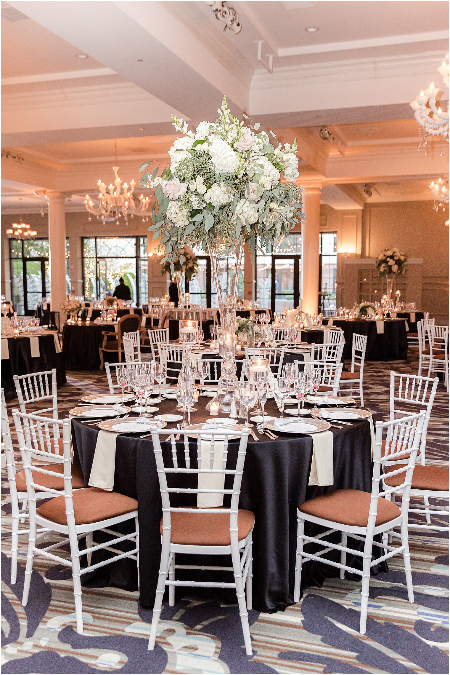 wedding reception with tall floral centerpieces at Vie by Cescaphe