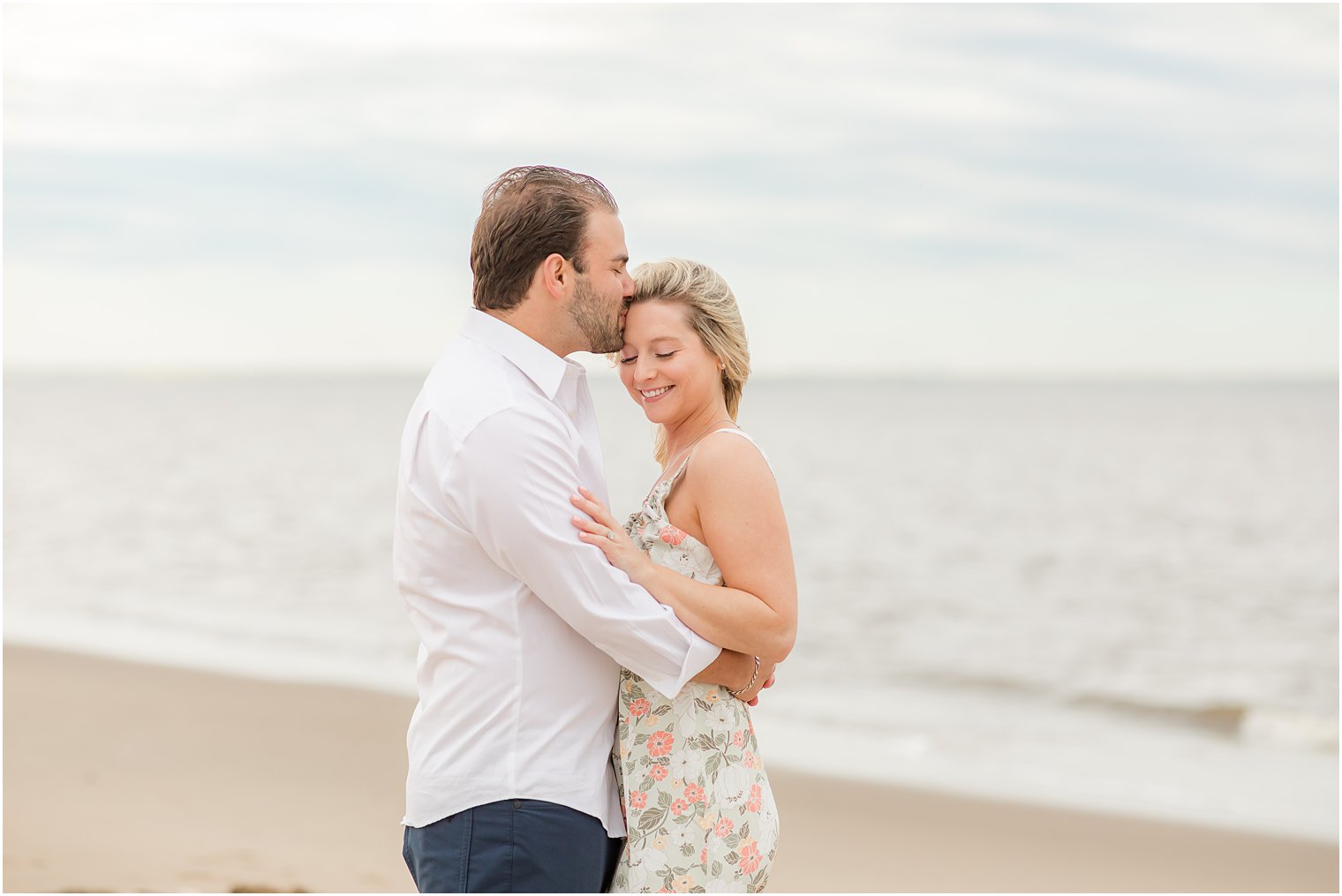man kisses woman's forehead during Union Beach engagement session 