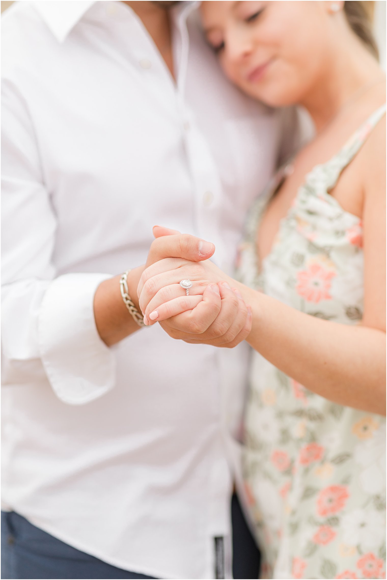 couple holds hands showing off bride's ring