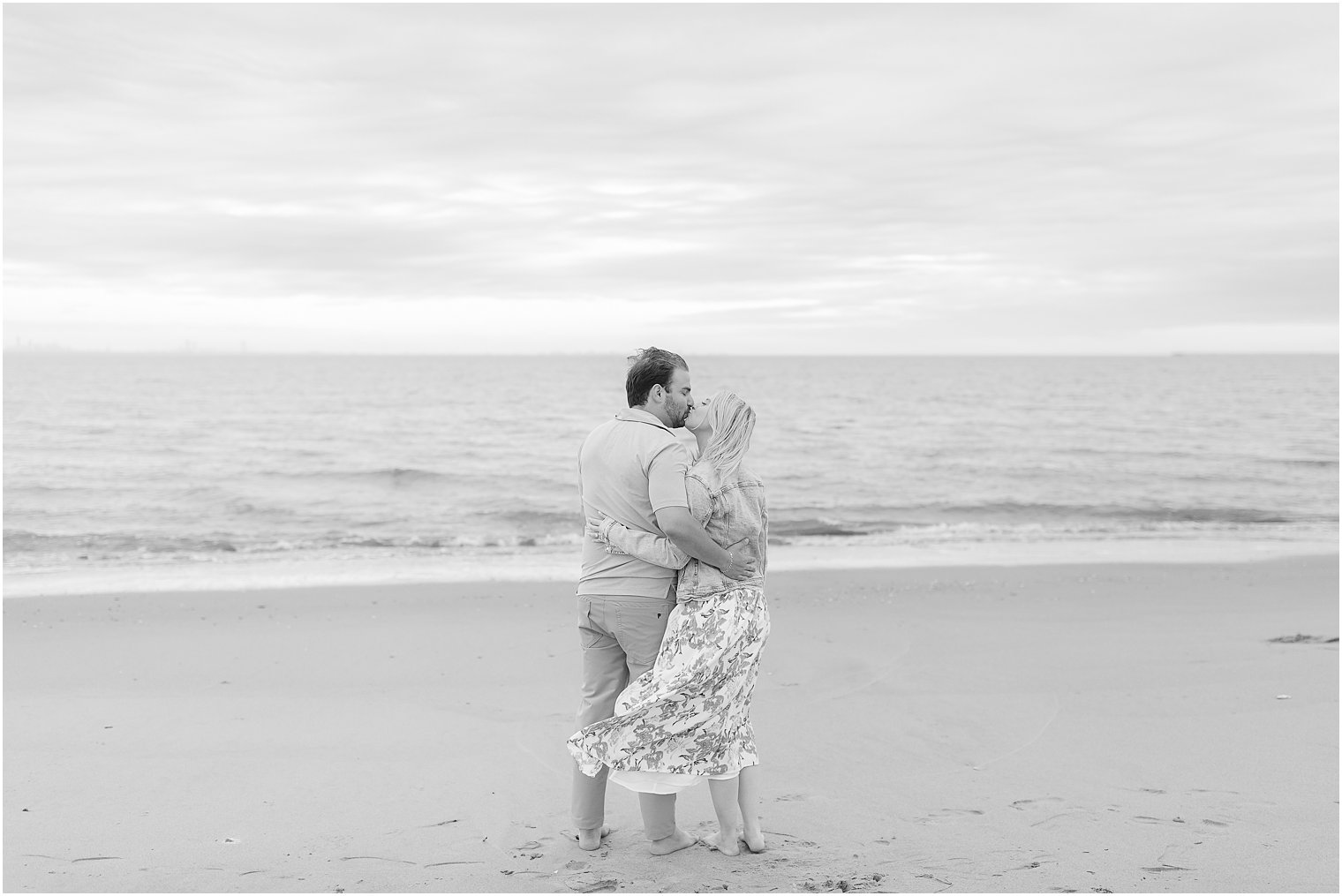 black and white portrait of couple kissing on beach in New Jersey 
