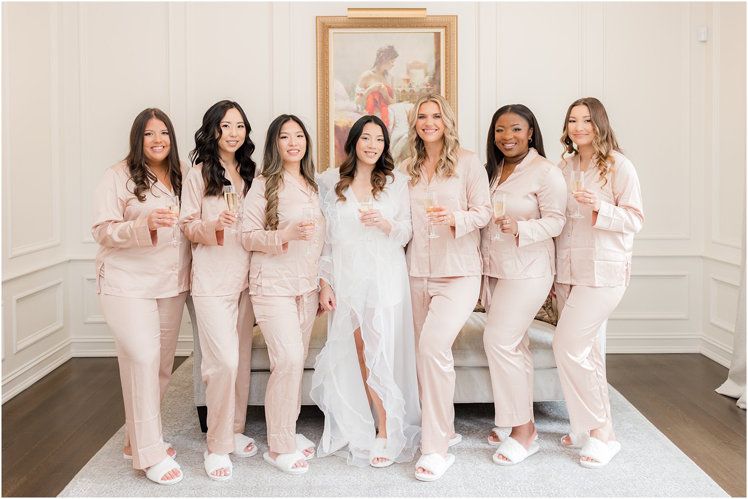 bride stands with bridesmaids in matching pajamas 