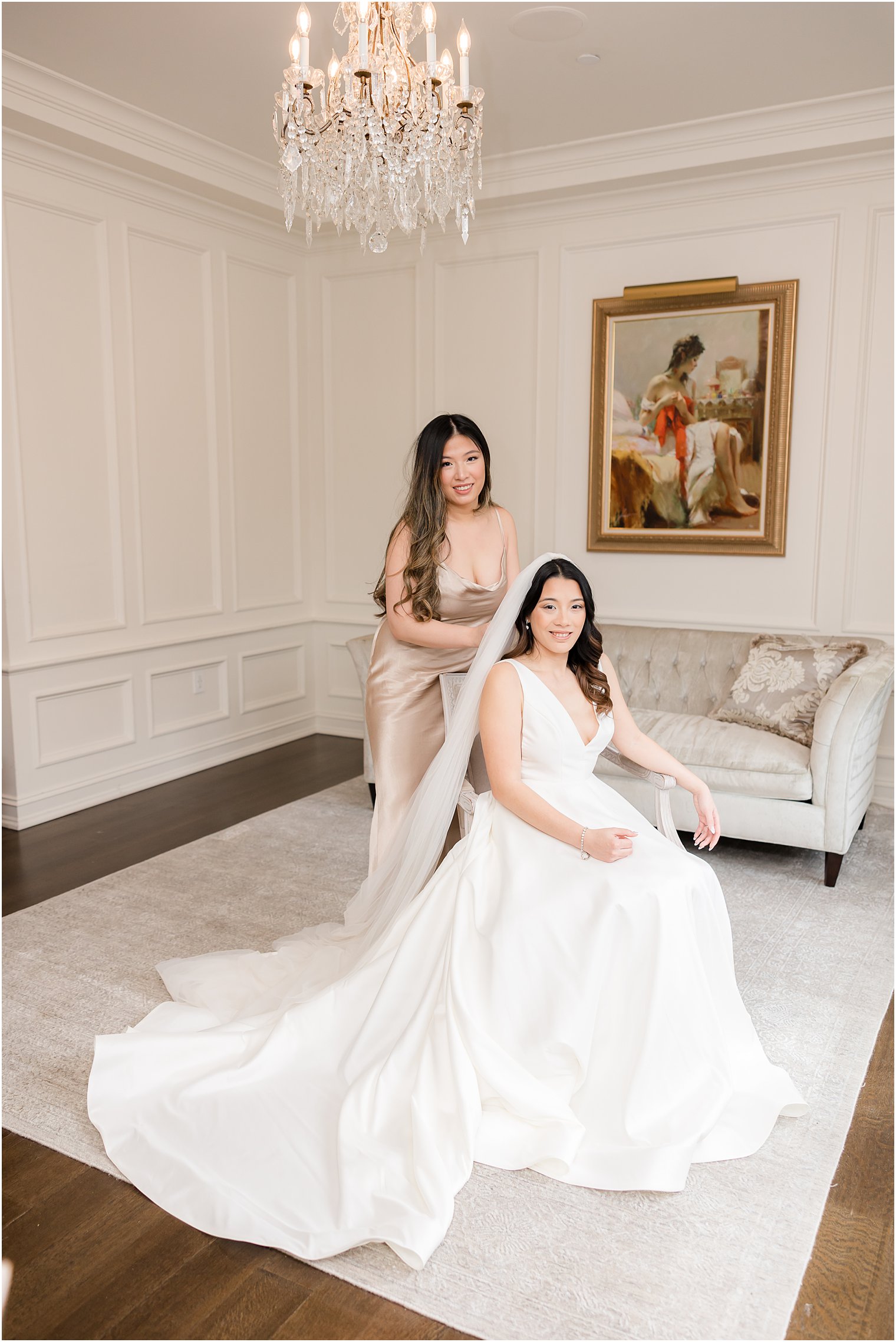 bridesmaid helps bride with veil in suite at Nanina's in the Park