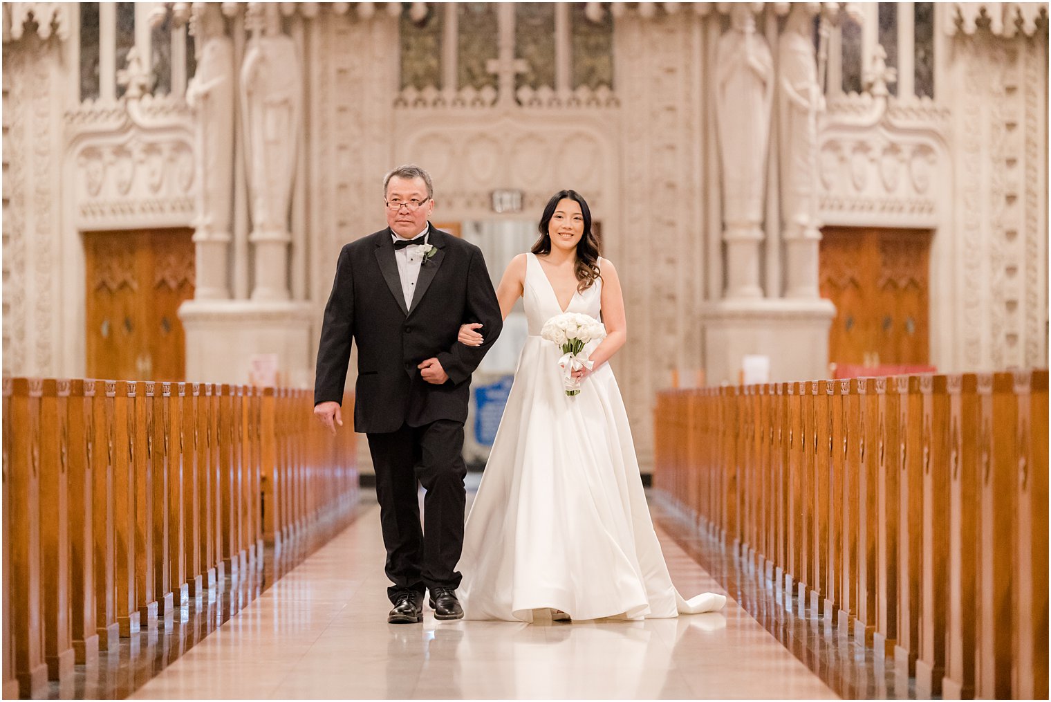 bride walks with father down aisle at The Cathedral Basilica of the Sacred Heart