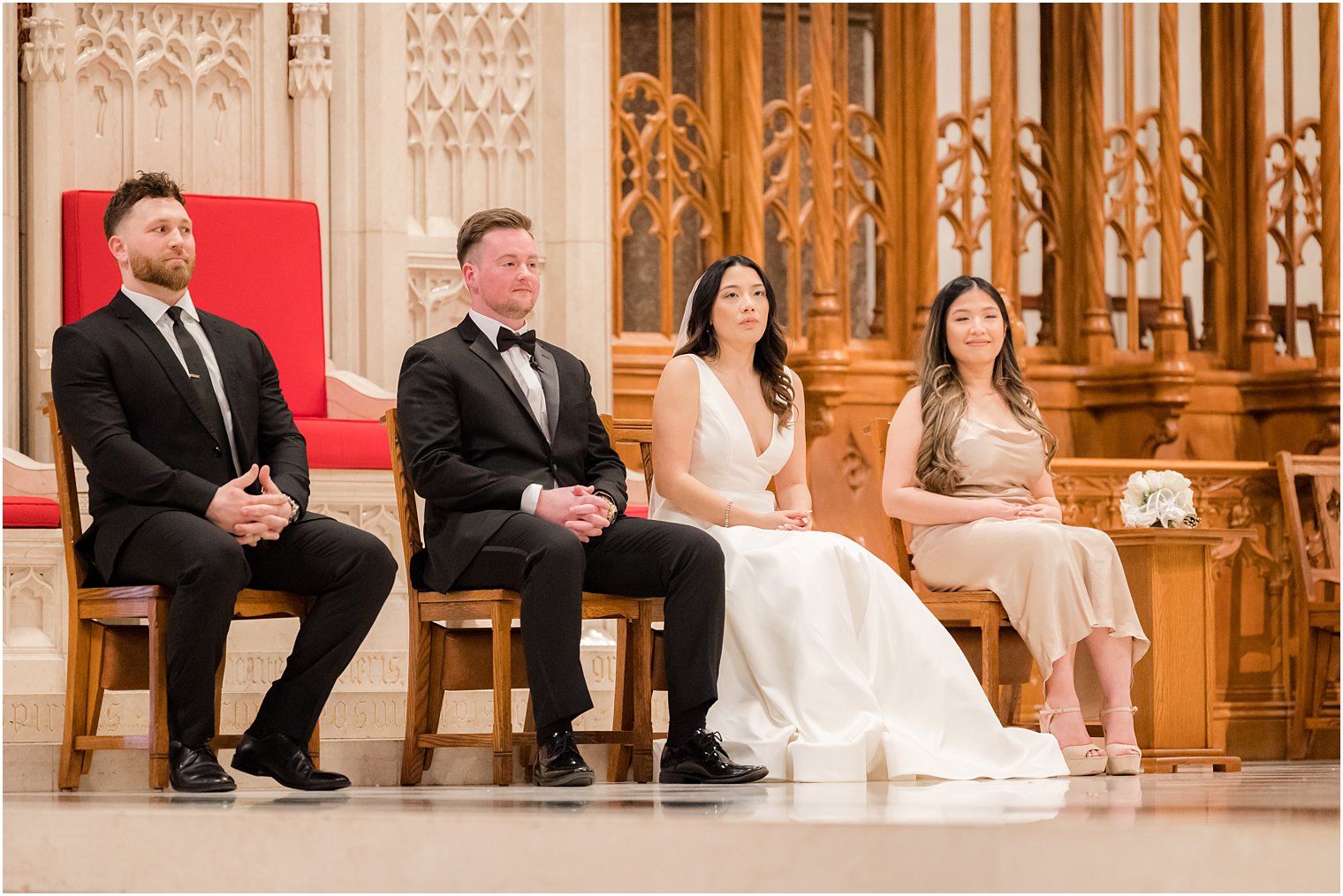 bride and groom sit listening to officiant speak 