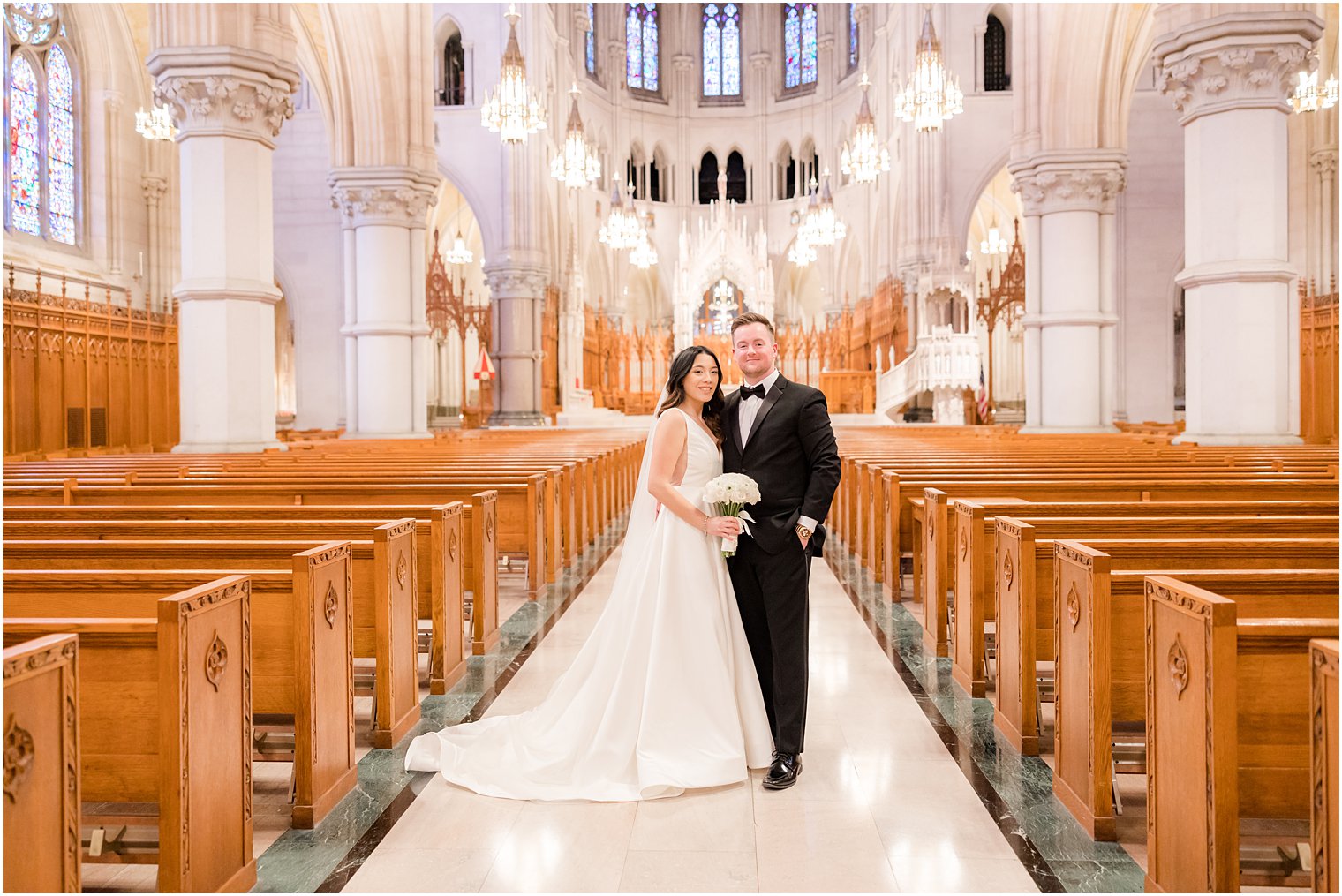 bride and groo mpose in aisle at The Cathedral Basilica of the Sacred Heart