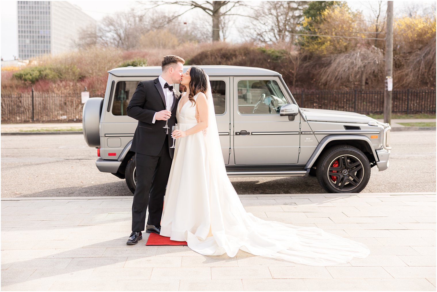 bride and groom kiss in front of custom jeep in Newark NJ