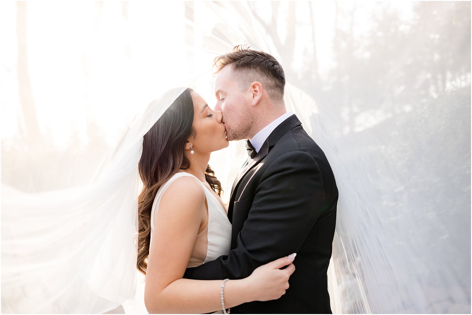 newlyweds kiss under bride's veil at Nanina's in the Park