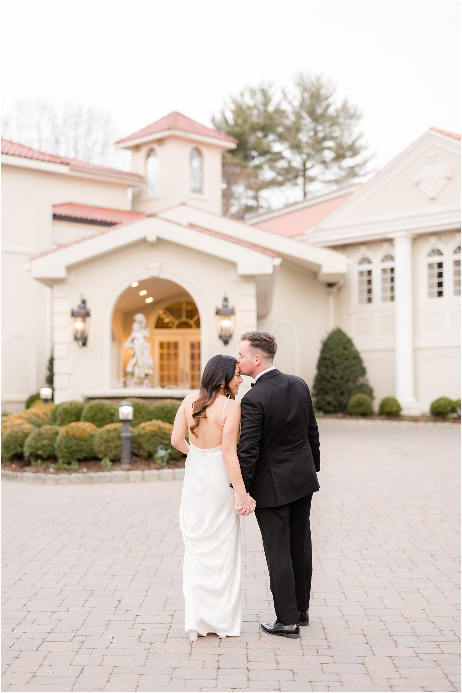 bride and groom hold hands walking outside Nanina's in the Park