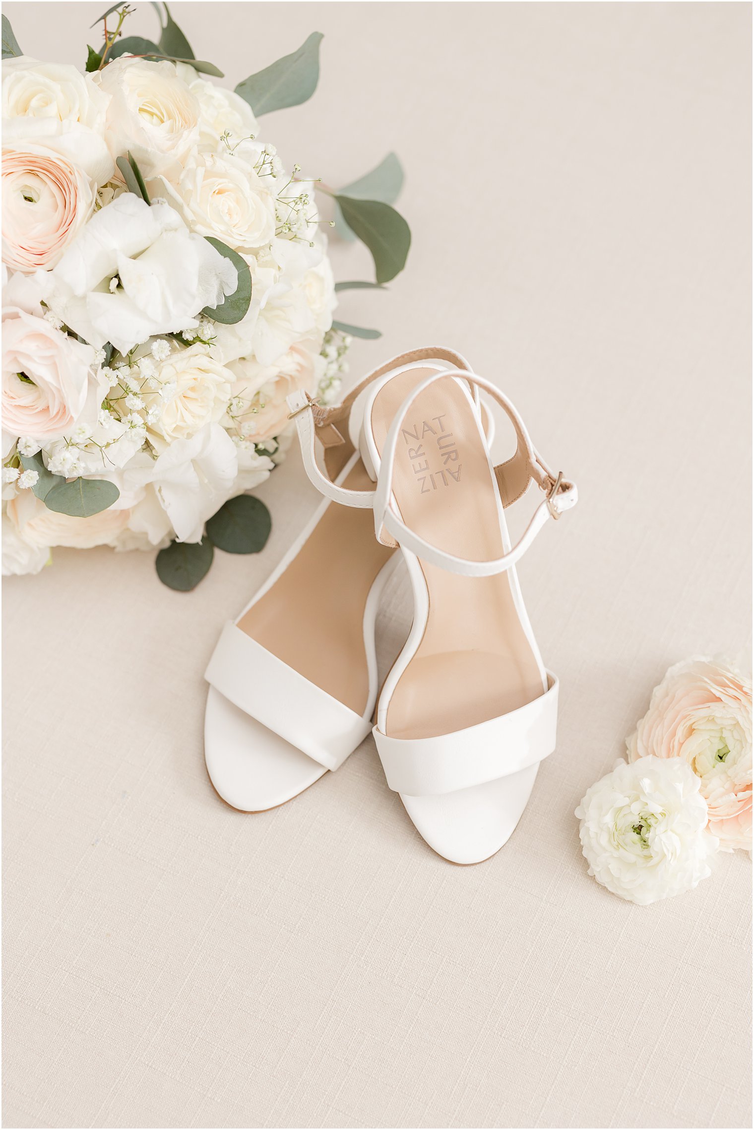 ivory shoes for bride by bouquet with white flowers and blush roses 