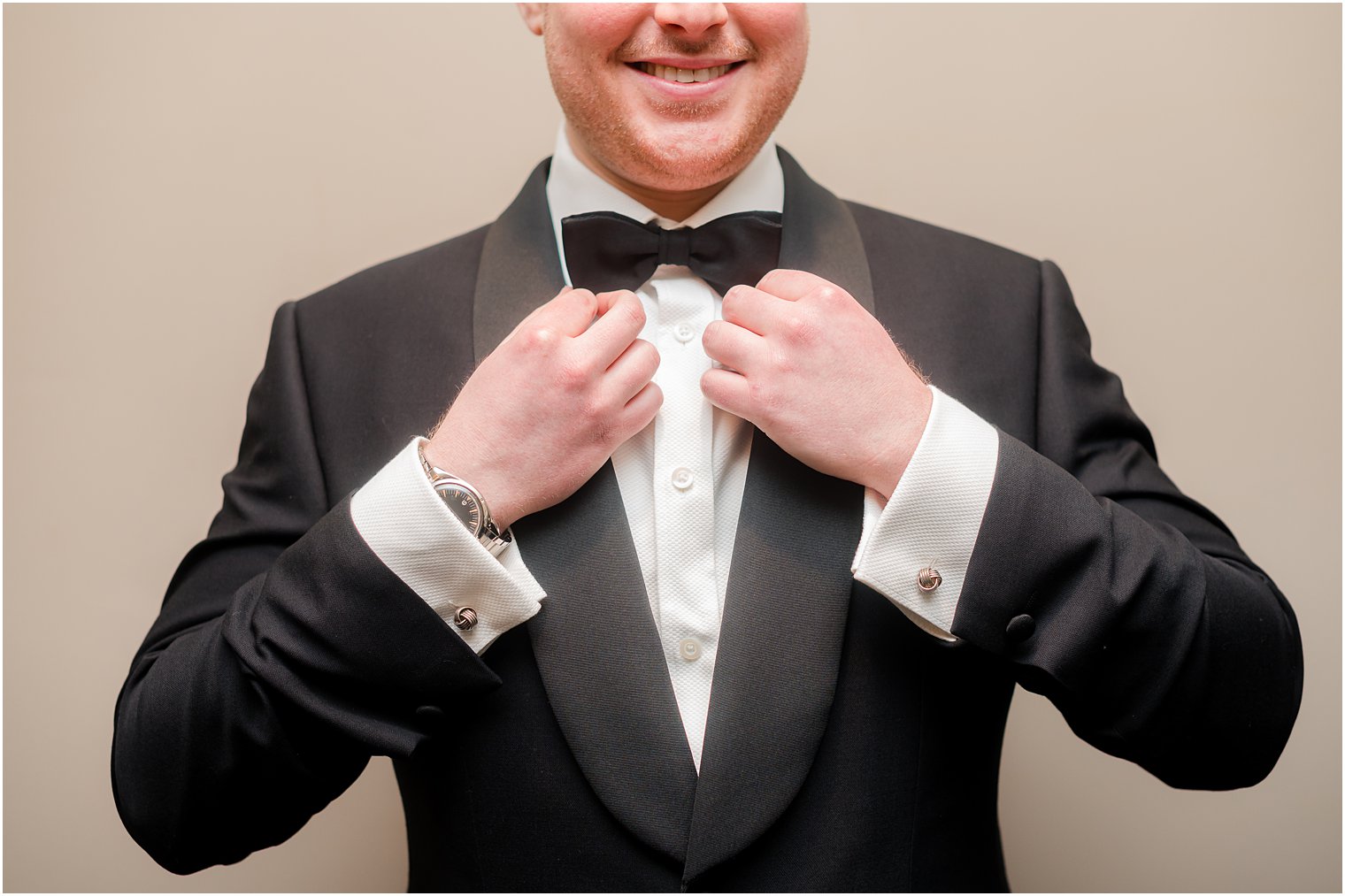 groom adjusts tie on suit jacket