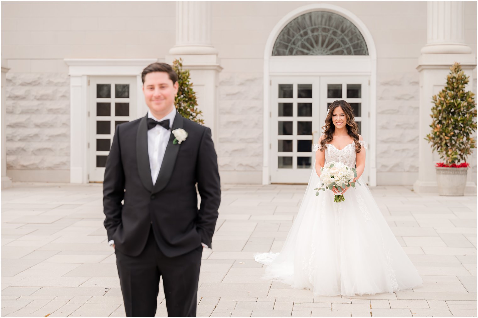 bride in ballgown wedding dress approaches groom outside the Palace at Somerset Park