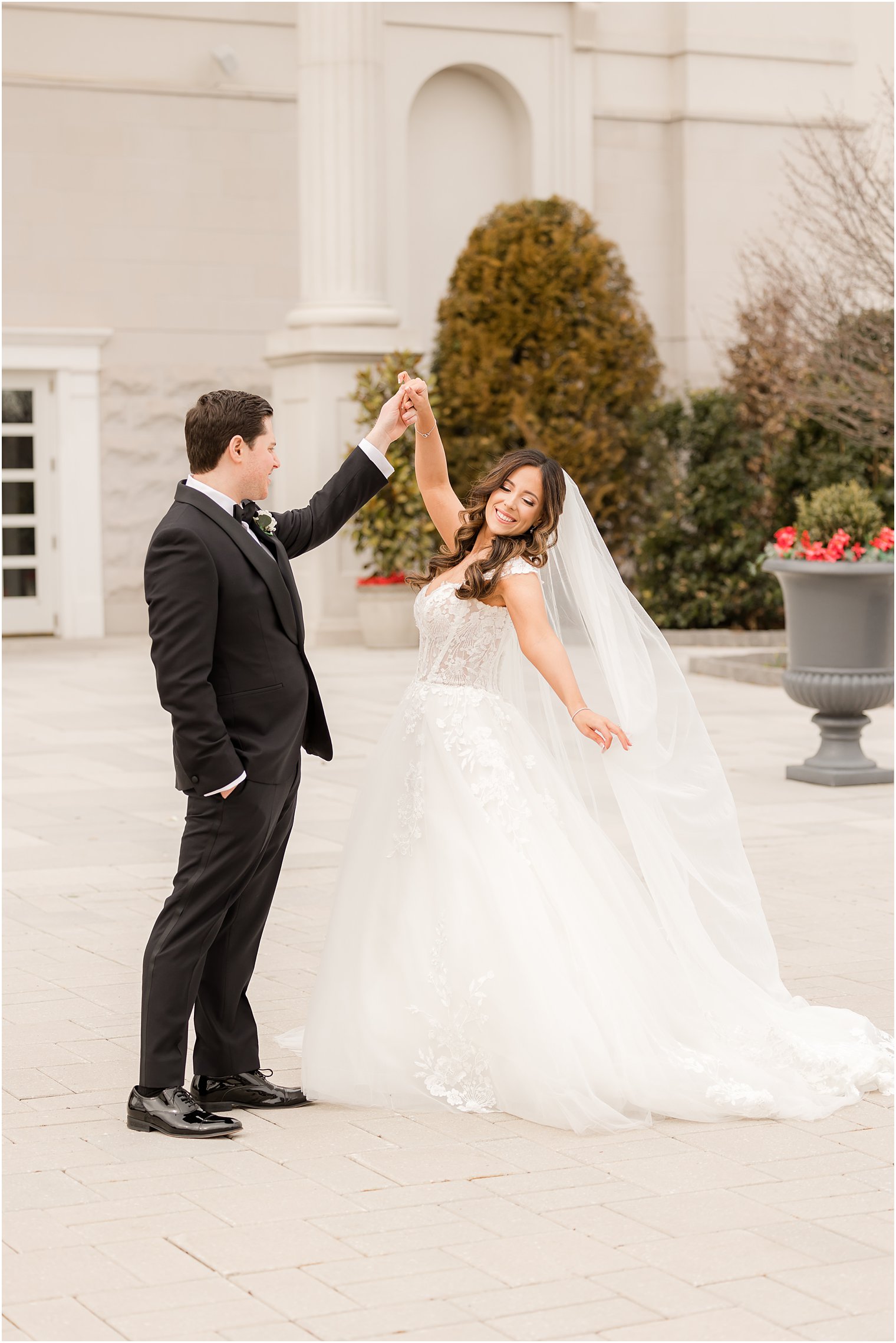 groom twirls bride outside the Palace at Somerset Park