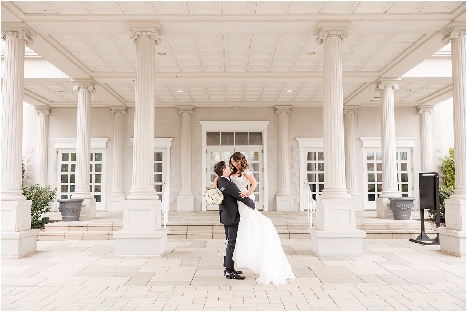 groom lifts bride under awning at the Palace at Somerset Park