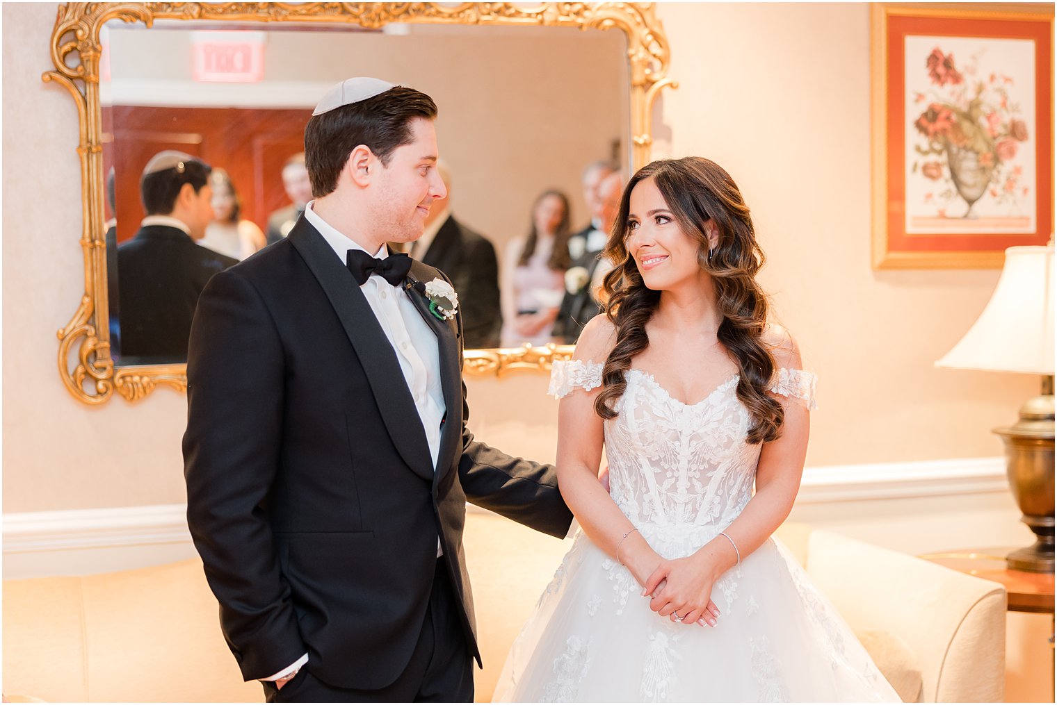 groom in black suit and yamaca smiles at bride