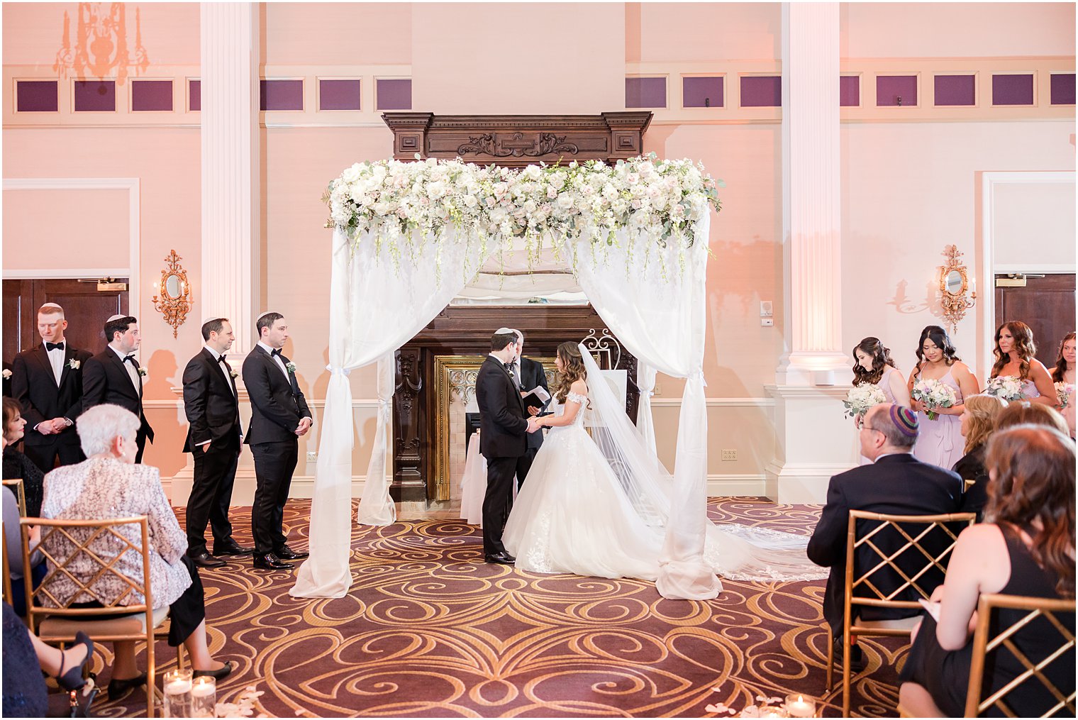 bride and groom hold hands during traditional Jewish wedding at the Palace at Somerset Park