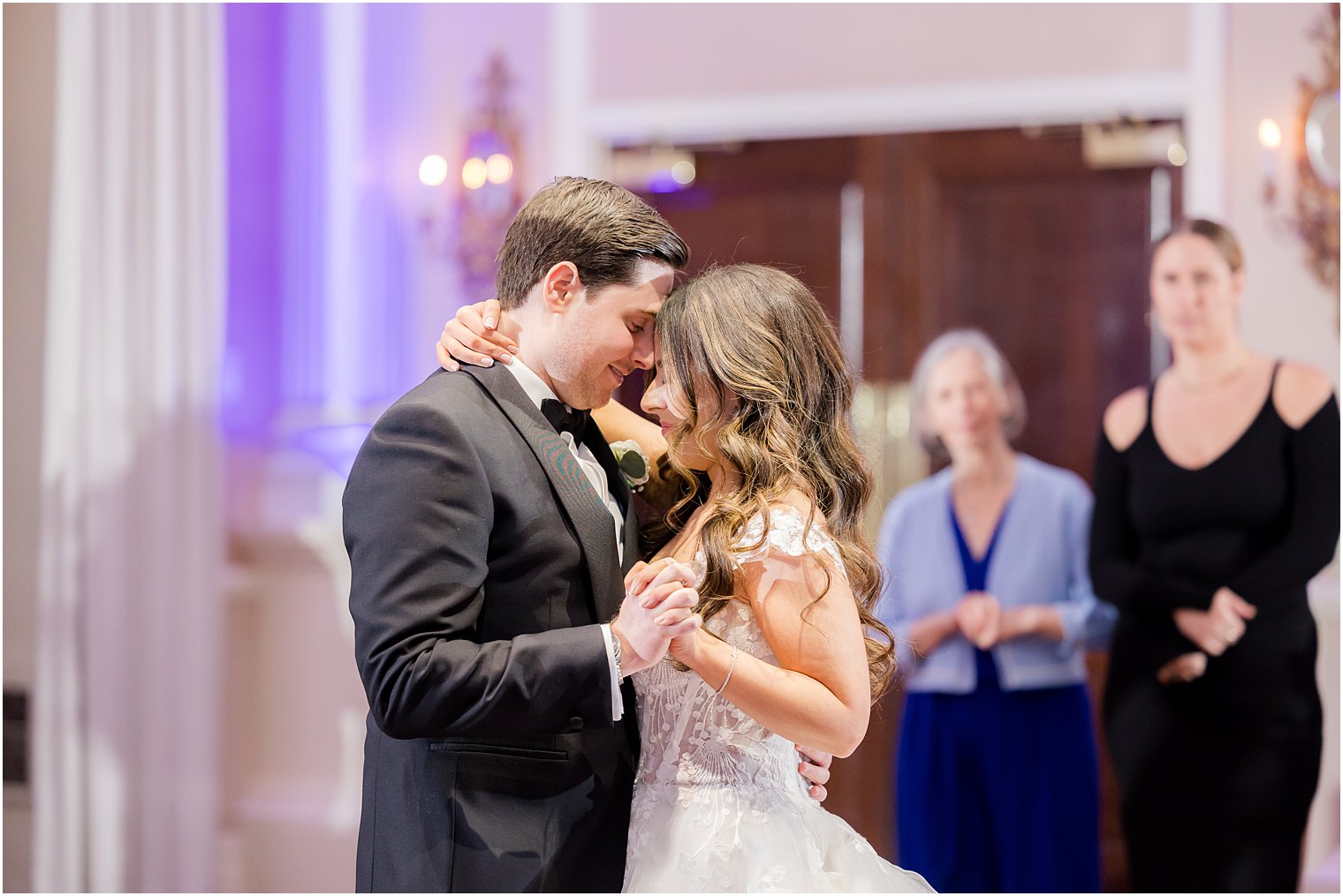 bride and groom lean heads together during first dance 