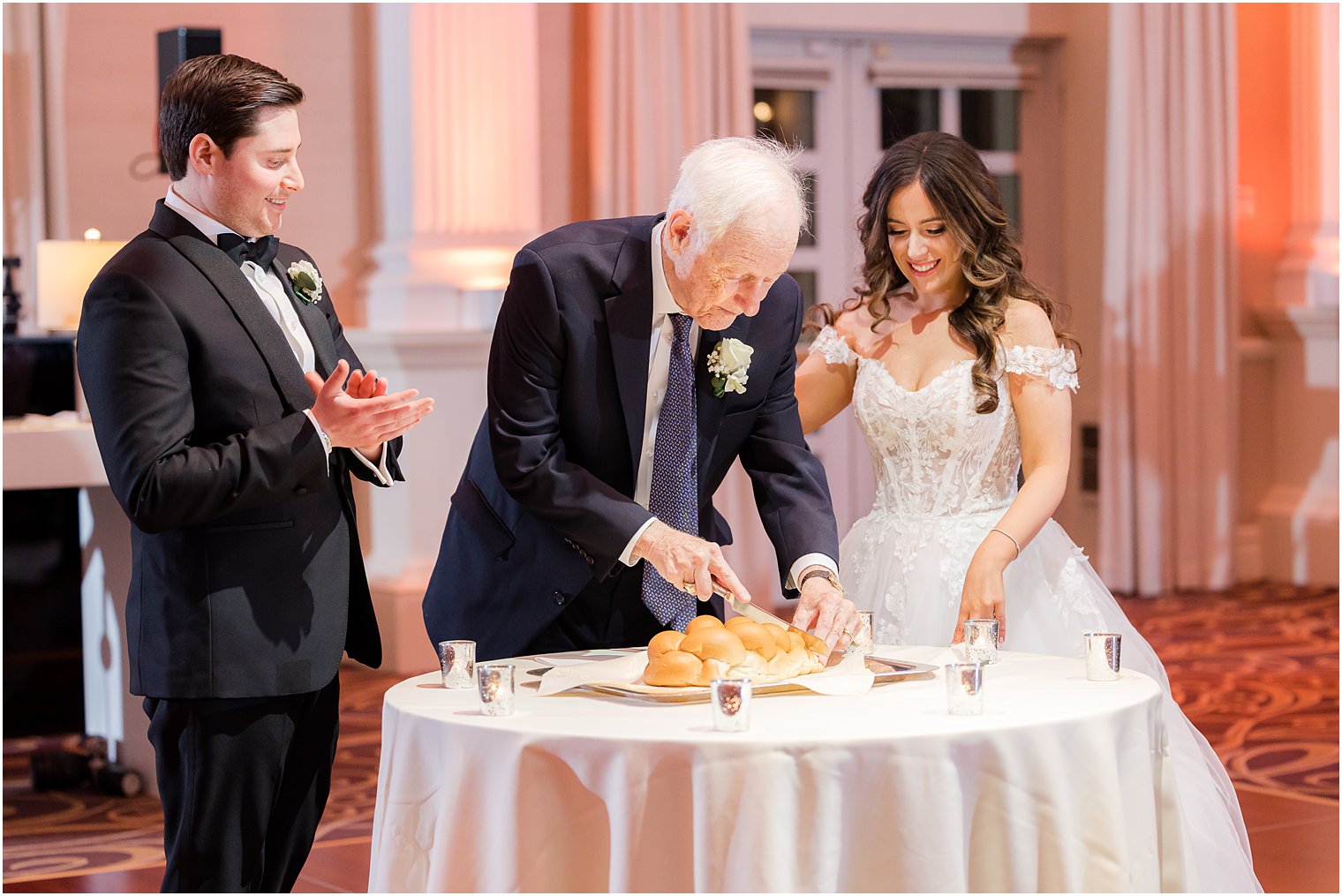 grandfather cuts bread during reception at the Palace at Somerset Park