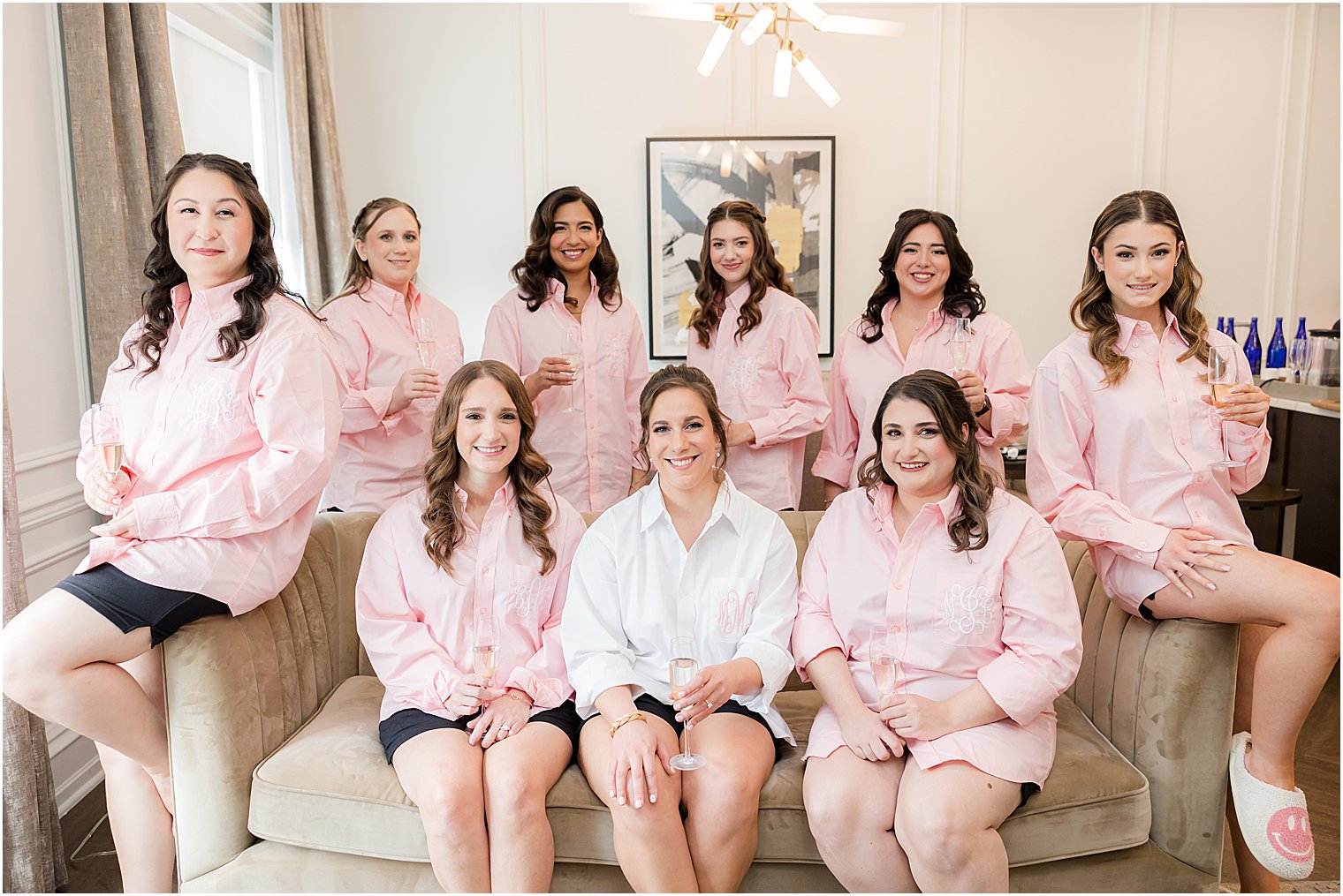 bride sits with bridesmaids in matching pink pajamas 