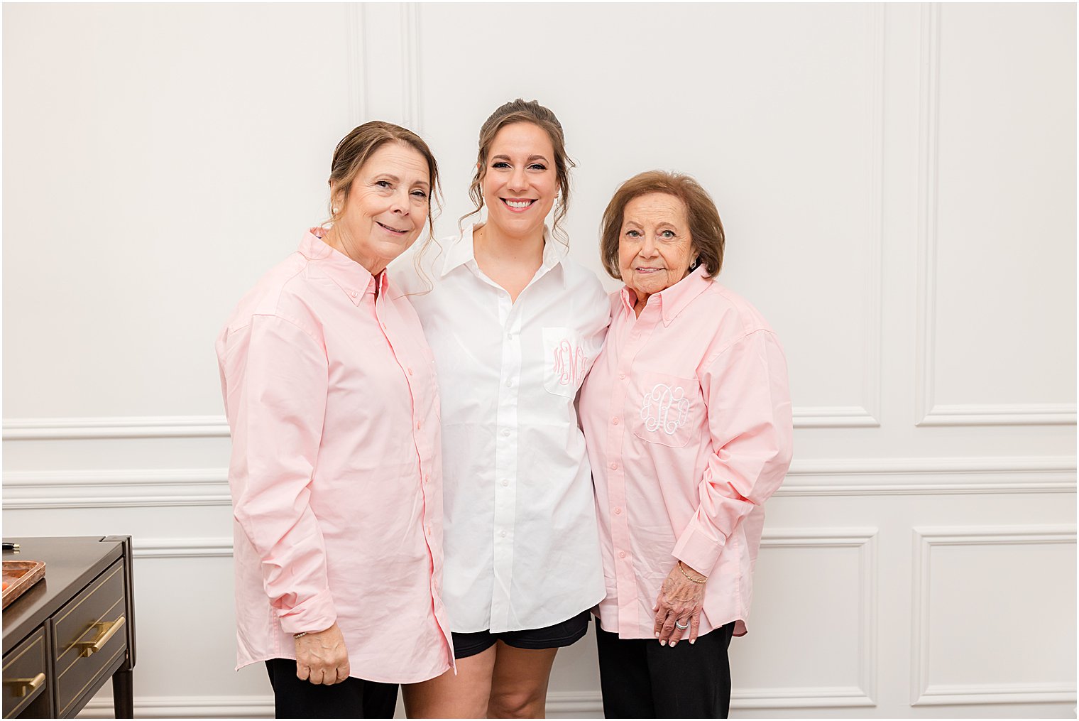 bride poses with mother and grandmother in pink pajamas 