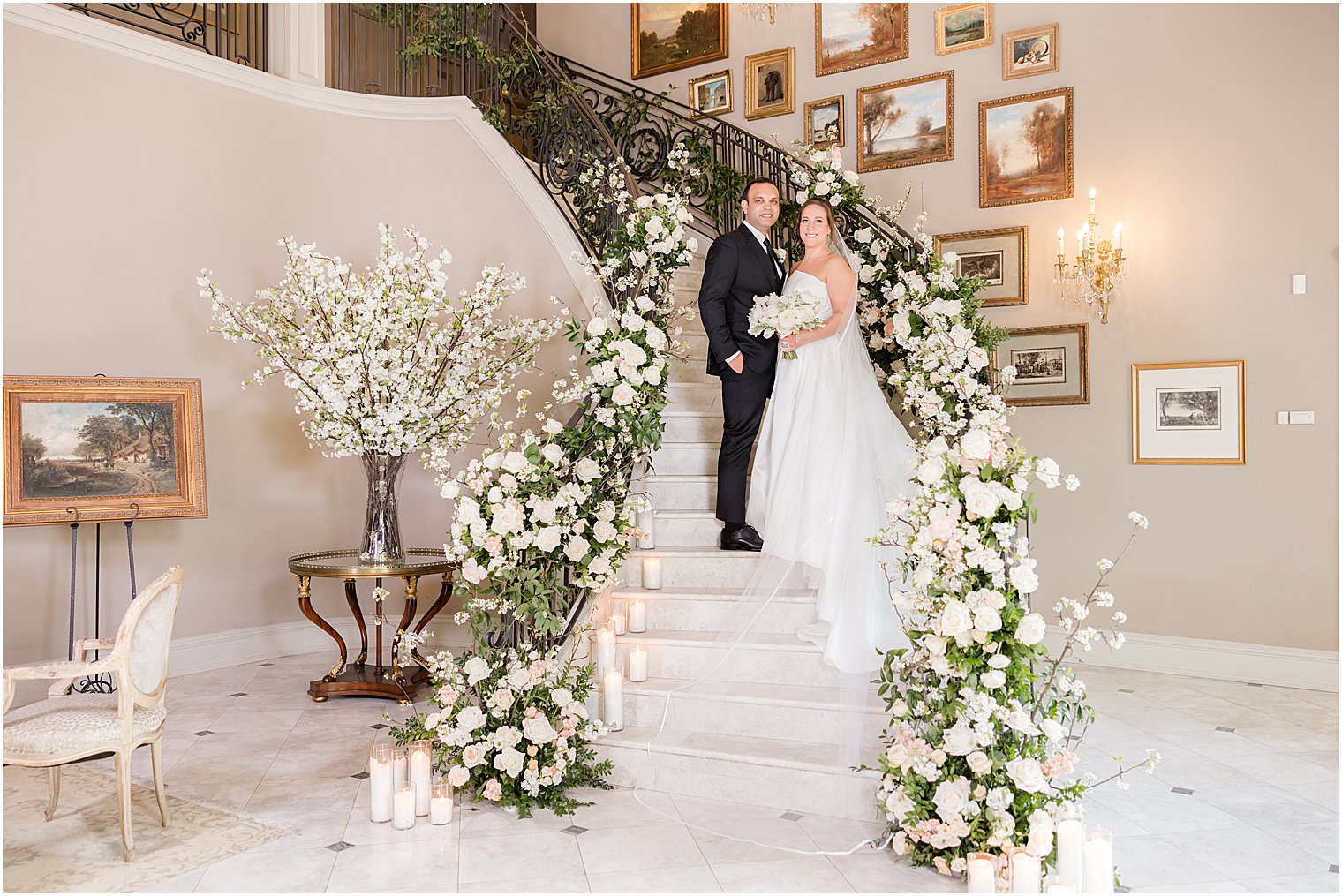 newlyweds stand on staircase with ivory rose flowers at Park Chateau Estate