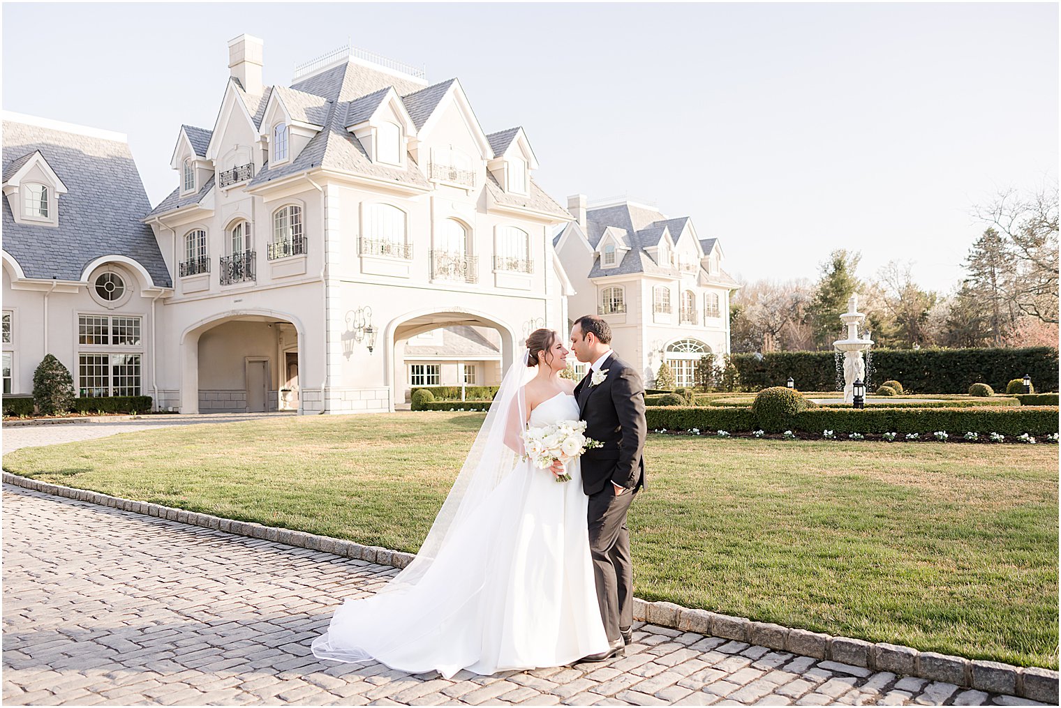 bride and groom hug with Park Chateau Estate behidn them 