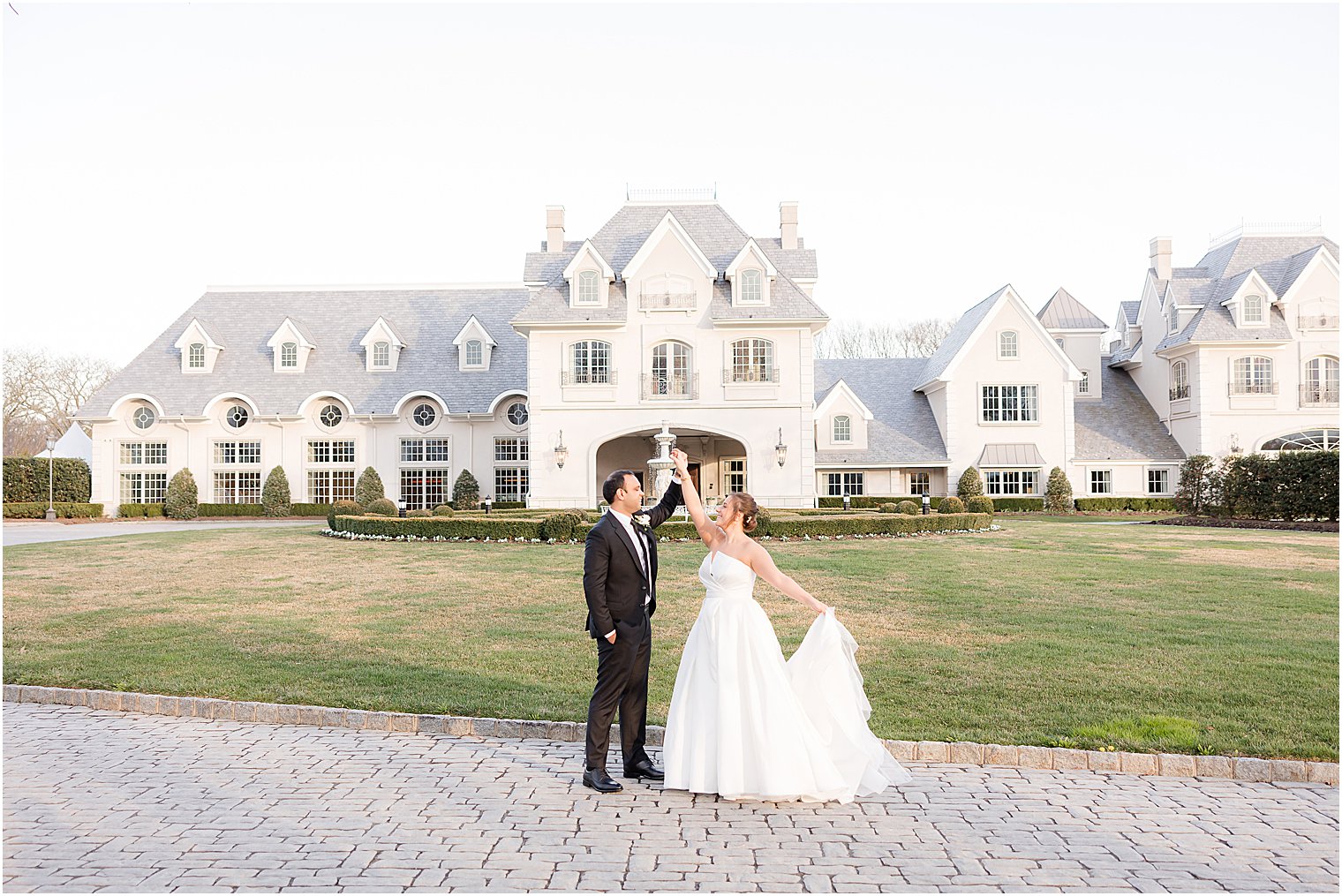 groom twirls bride in front of Park Chateau Estate
