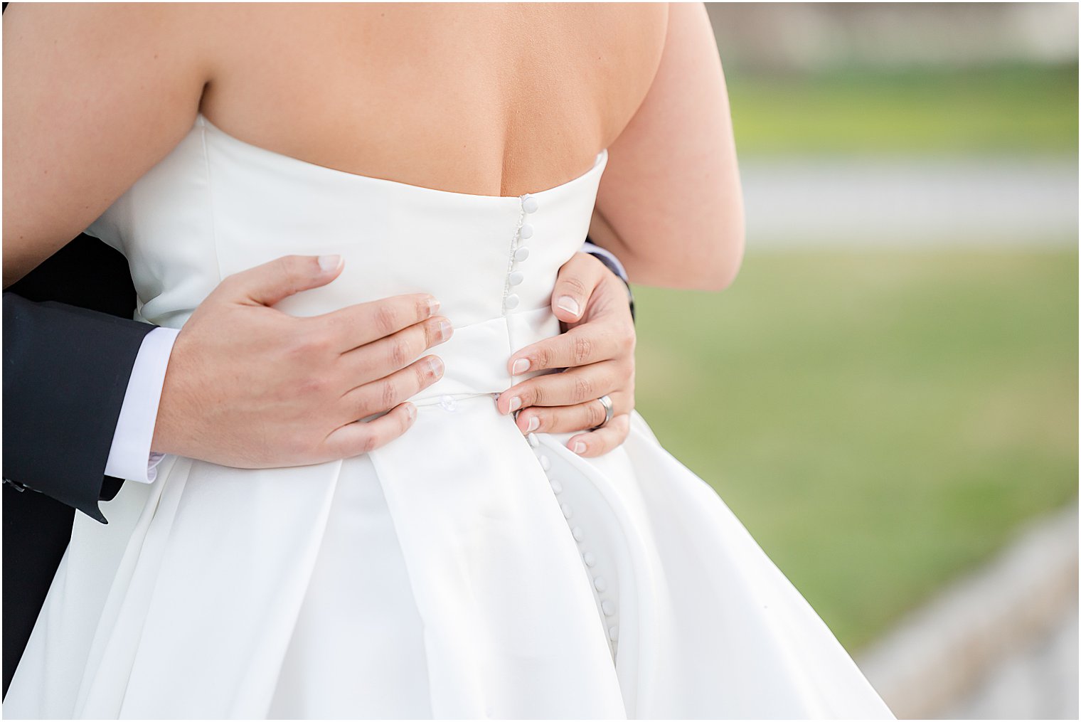 groom holds bride's waist in strapless gown 