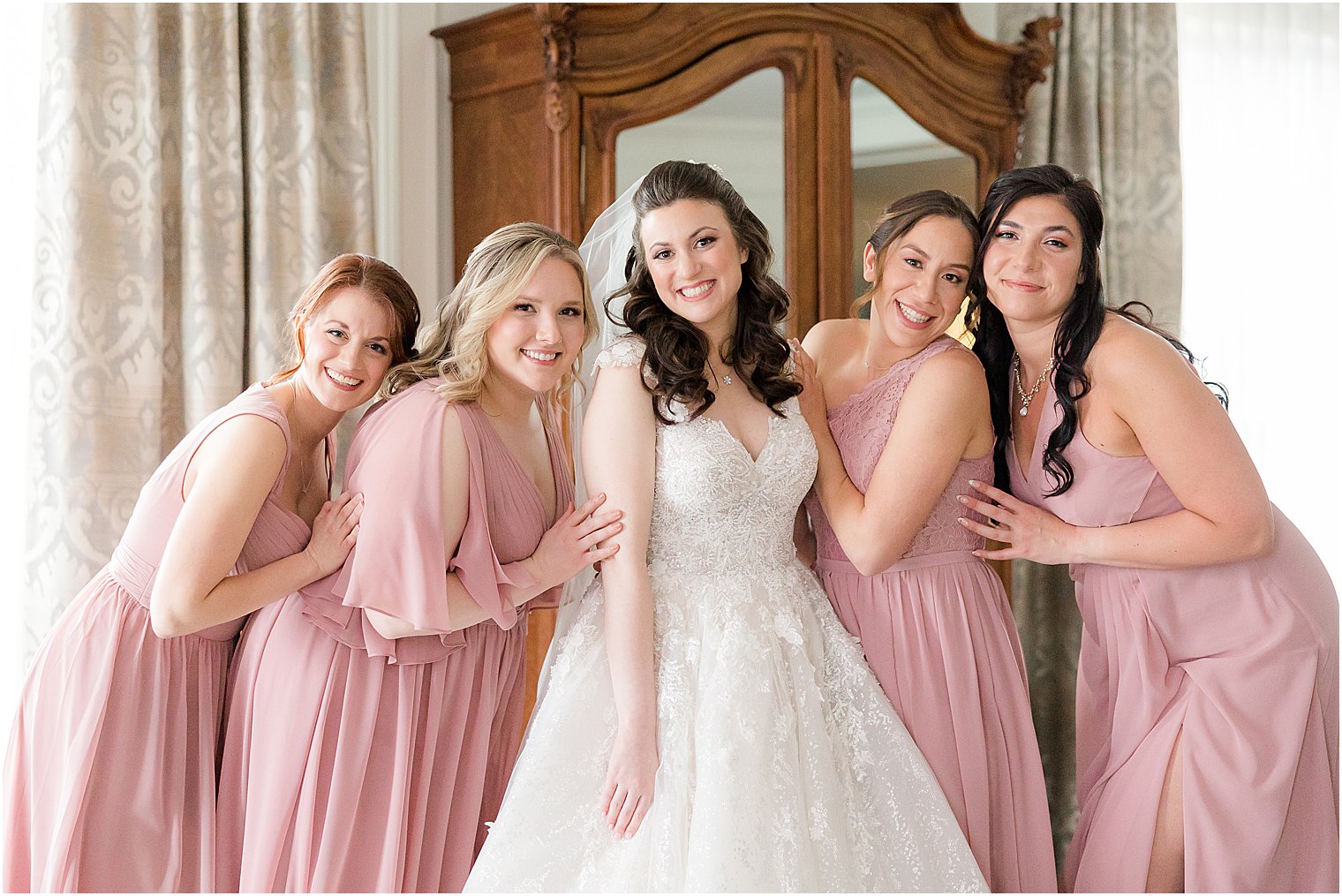 bride poses with bridesmaids in pink gowns in bridal suite at Park Savoy Estate