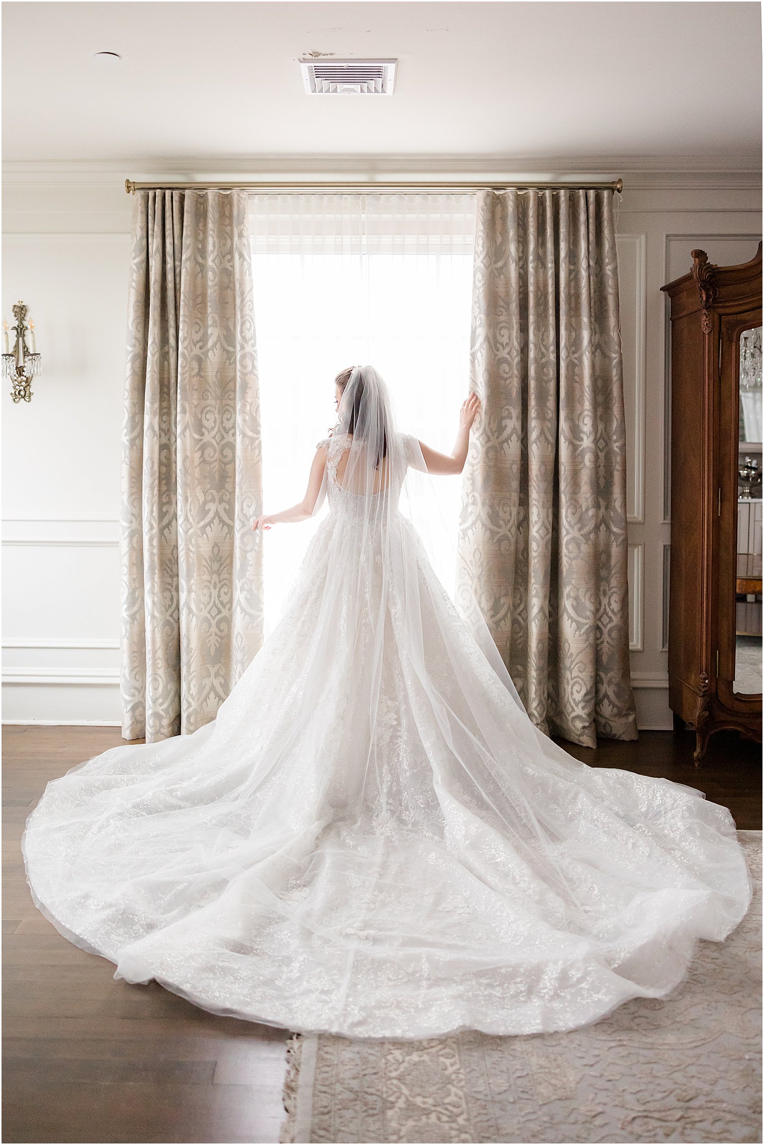 bride poses in window with train of dress around her at Park Savoy Estate