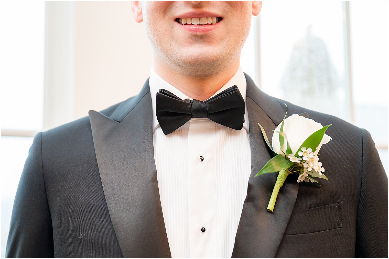 groom's classic black tux and white rose boutonnière 