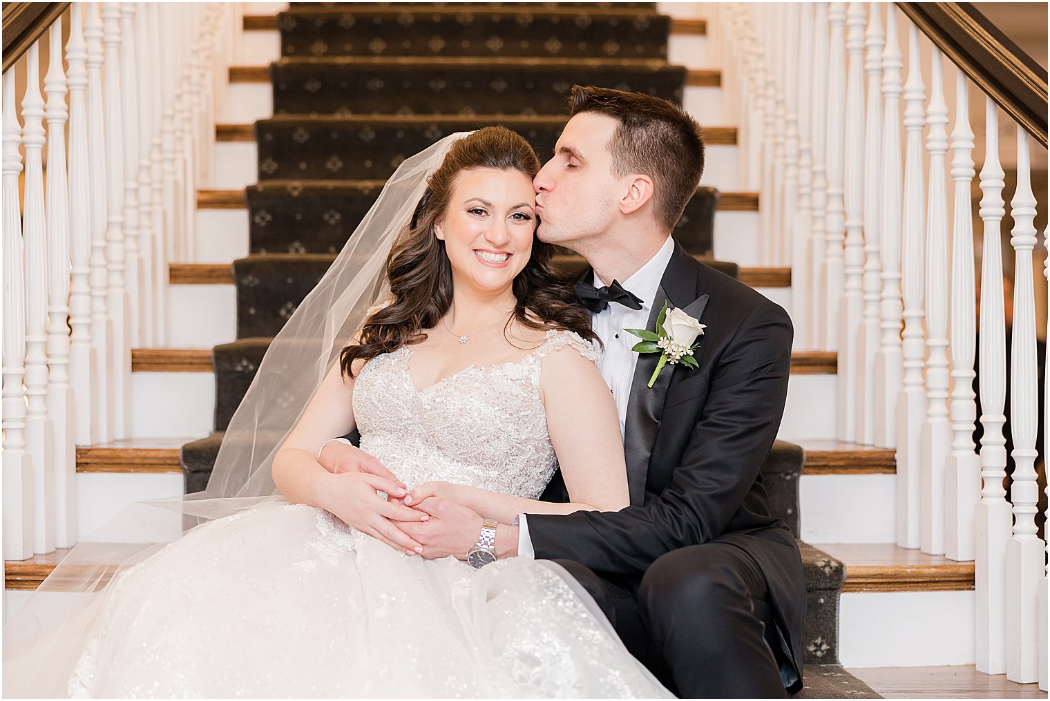 groom hugs bride on steps inside Park Savoy Estate kissing her forehead 