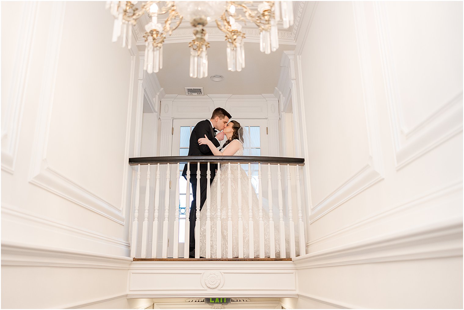 bride and groom kiss on balcony inside Park Savoy Estate