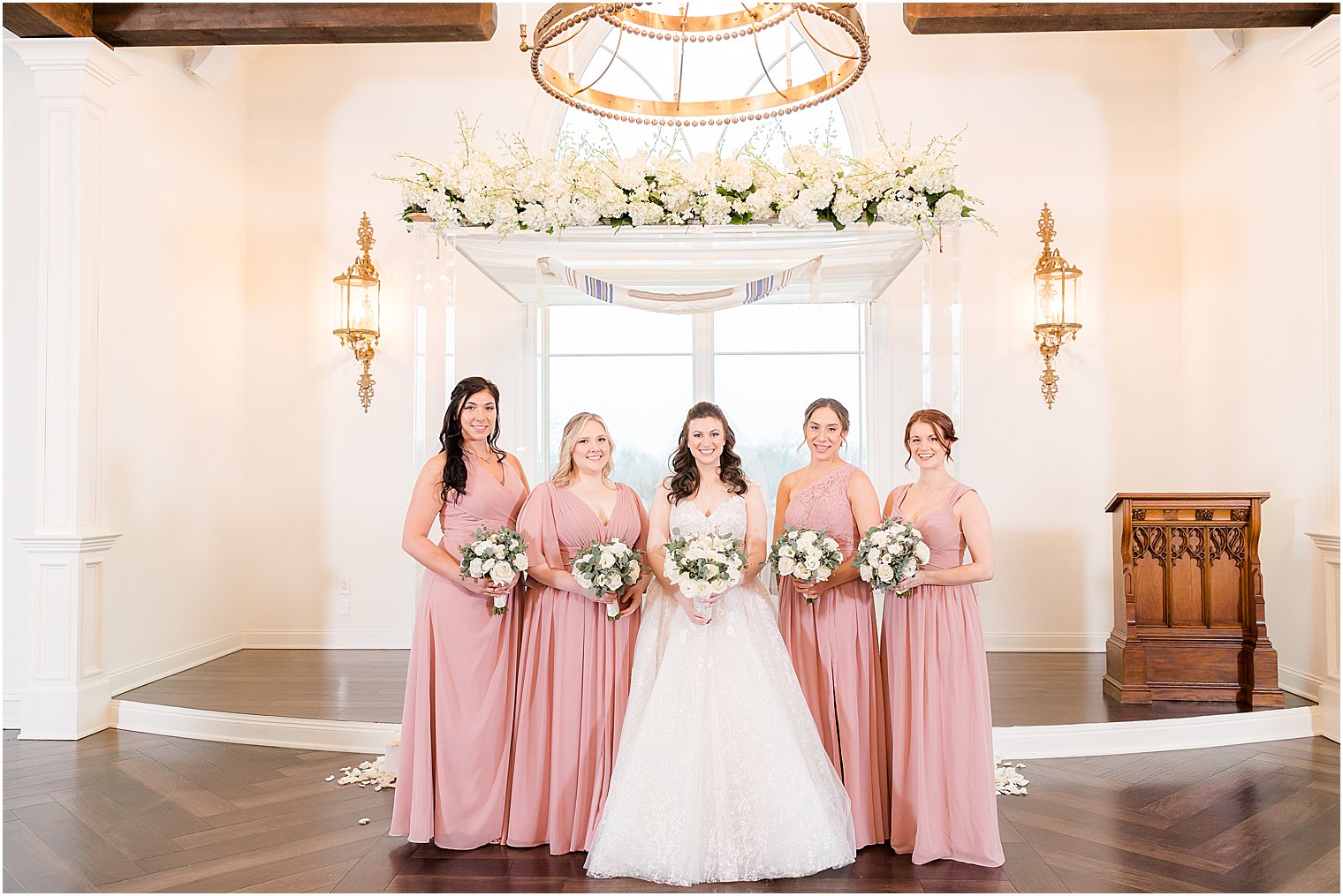 bride poses with four bridesmaids in pink gowns 