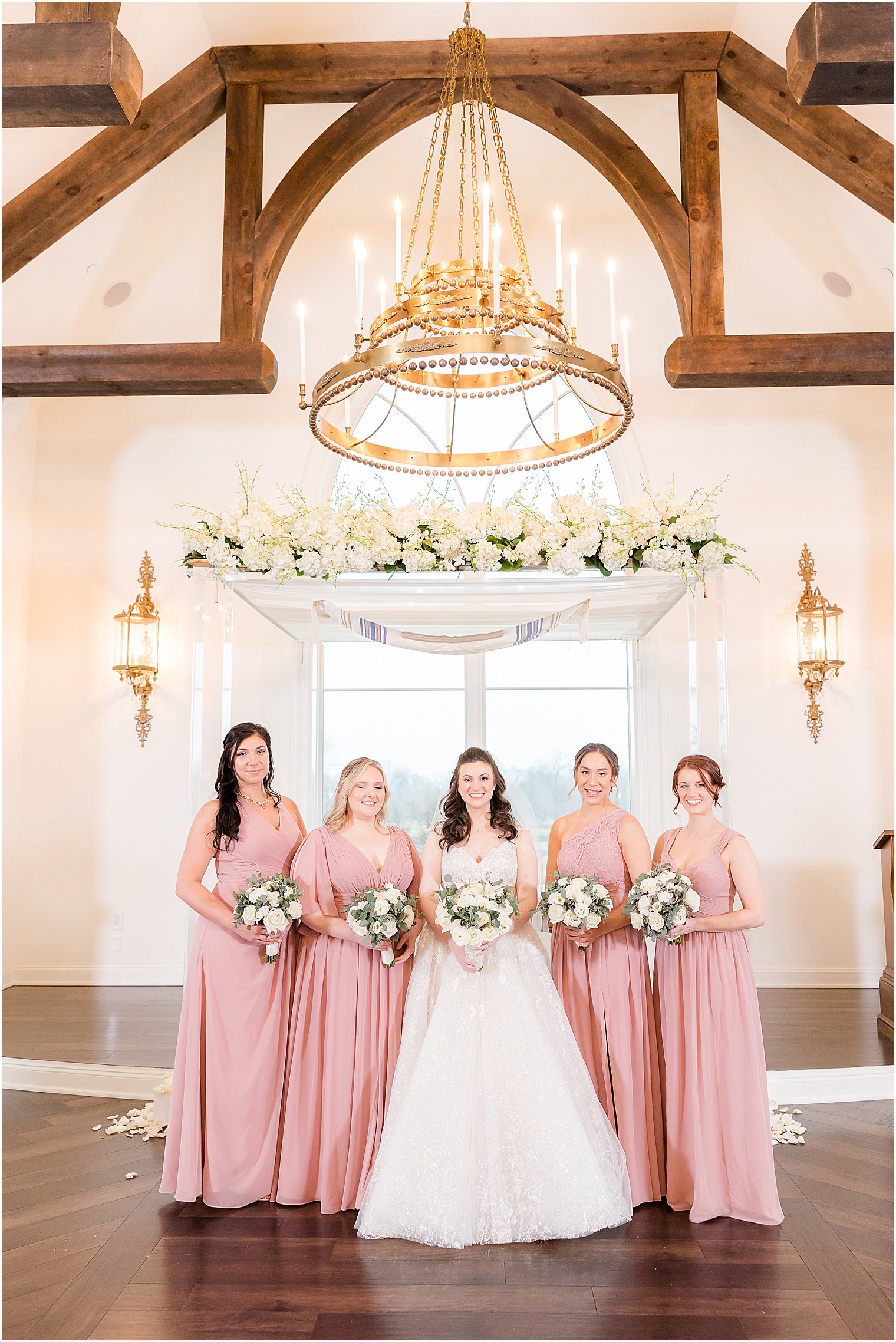 bride stands with four bridesmaids in pink gowns in chapel at Park Savoy Estate