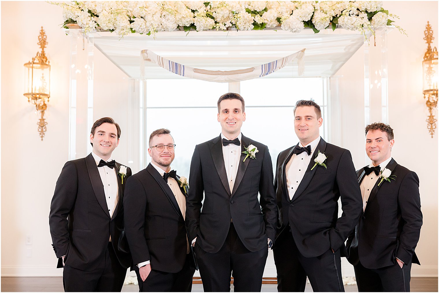groom stands with groomsmen in black suits at Park Savoy Estate